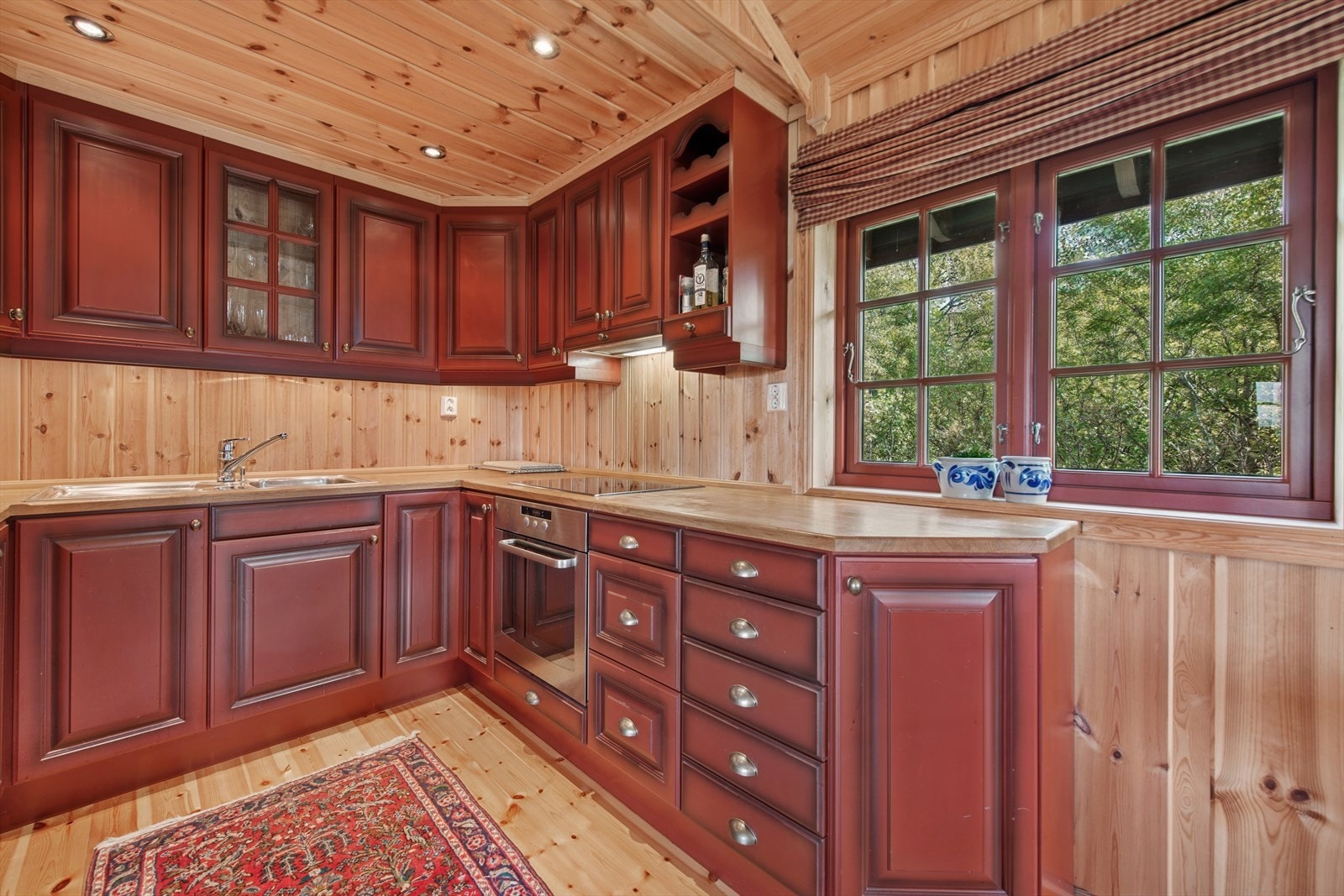 Kjøkkenet har en innredning med profilerte fronter og benkeplate i heltre - utstyrt med kjøl/fryseskap og oppvaskmaskin, platetopp og stekeovn. Galleribilde