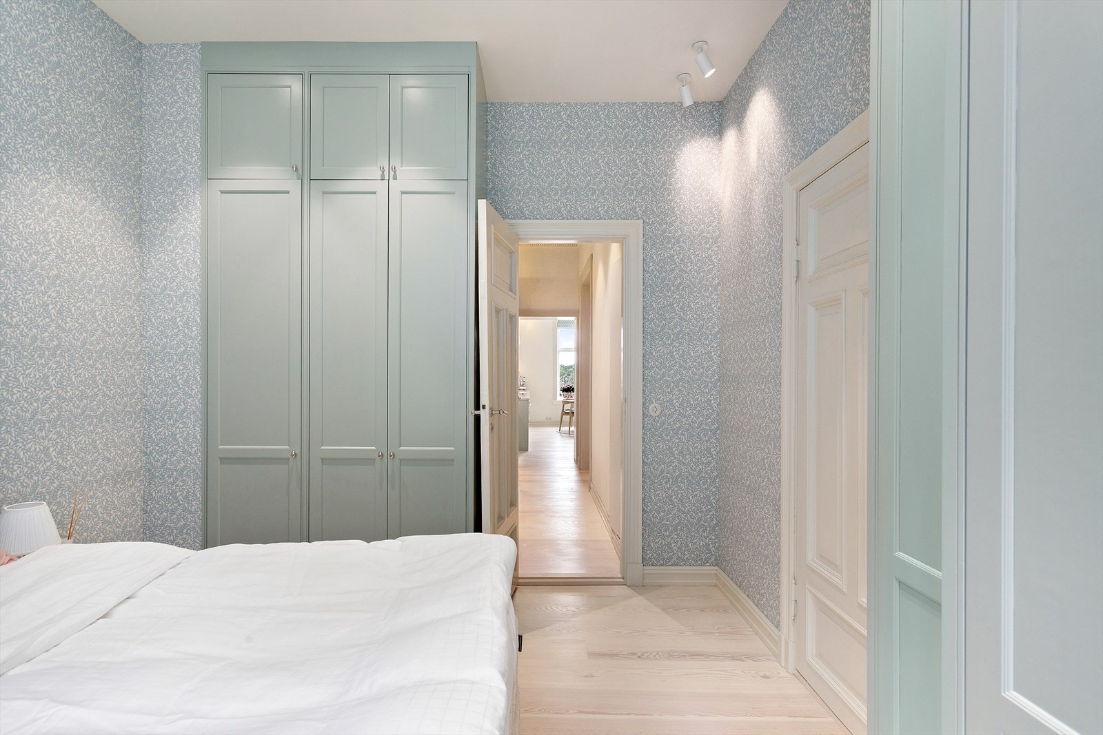 Den harmoniske kombinasjonen av blå tapet og grønne skap skaper et unikt og friskt uttrykk i rommet. Galleribilde