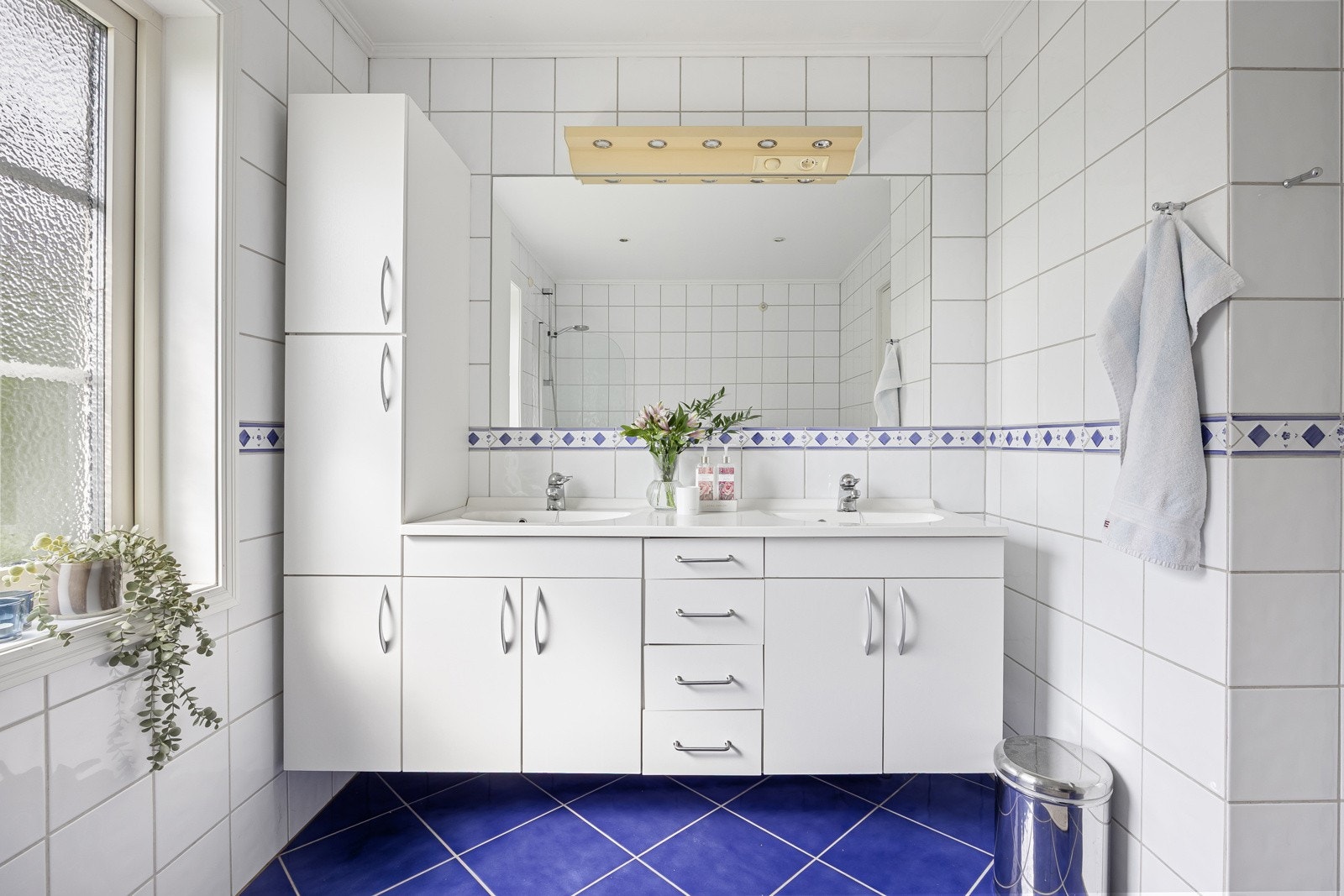 Badet er helfliset og har en hvit servantinnredning med god skapplass og heldekkende dobbelservant. Galleribilde