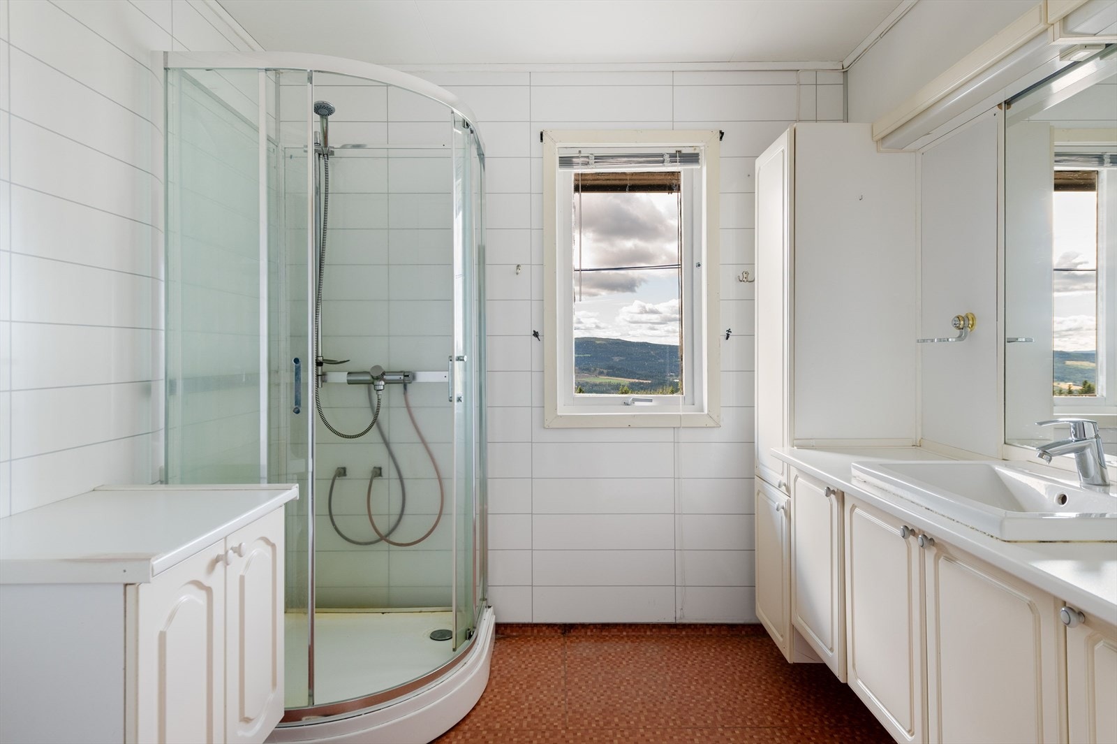 Baderommet i første etasje er innredet med servant med underskap dusjkabinett og gulvmontert toalett. Galleribilde