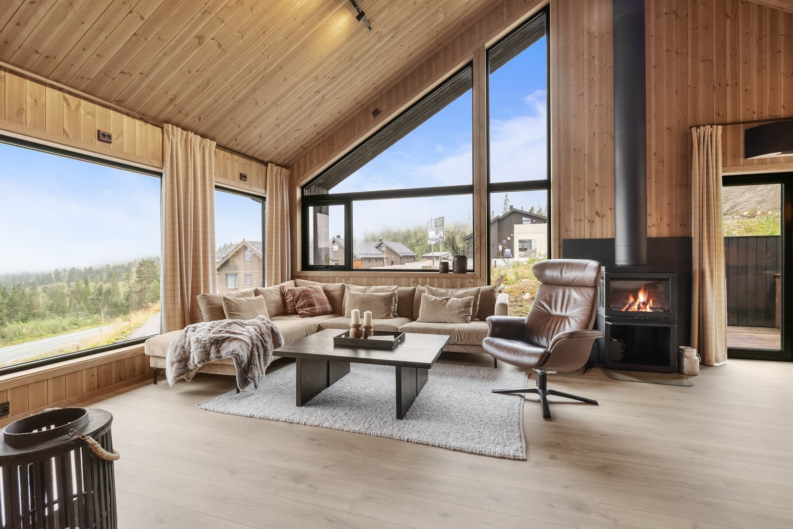 Moderne og innbydende hyttestil med lune beisede trepaneler og tidsriktige materialvalg Galleribilde