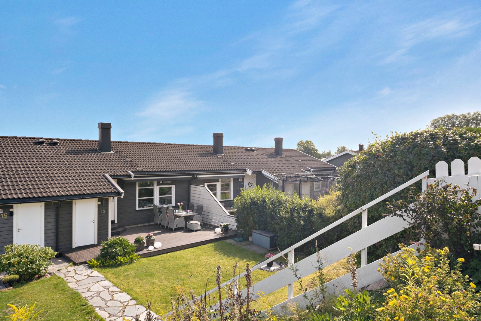 Eiendommen har et lekkert uteområde med både platting og gressplen Galleribilde