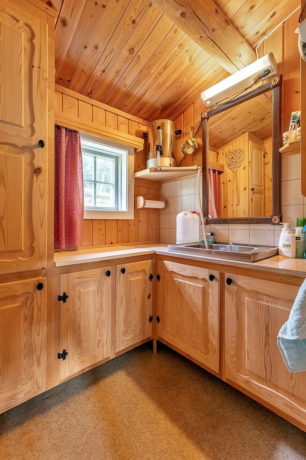 Vaskerommet har gulvvarme og innredning i heltre med elektrisk vannvarmer og servant Galleribilde