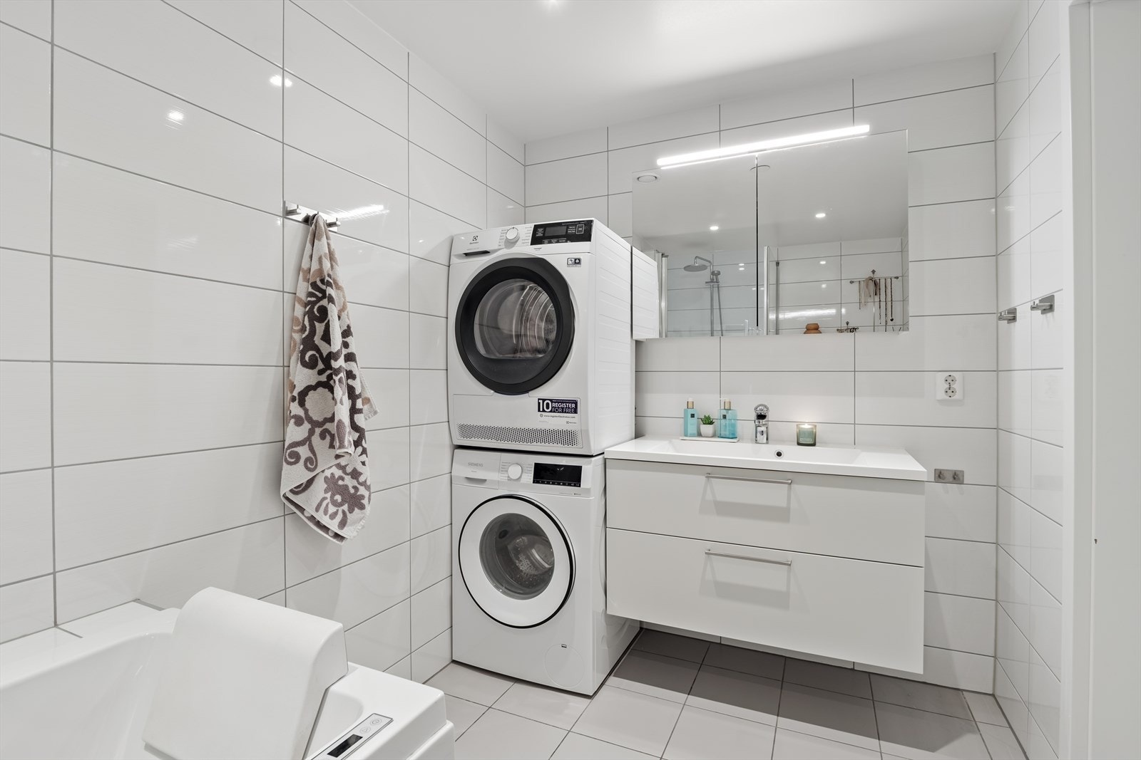 Badekaret er strategisk og pent plassert i en opprinnelig dusjsone med flislagt kant. Dette kan ved ønske tilbakestilles slik at badet får en stor og herlig dusjsone. Galleribilde