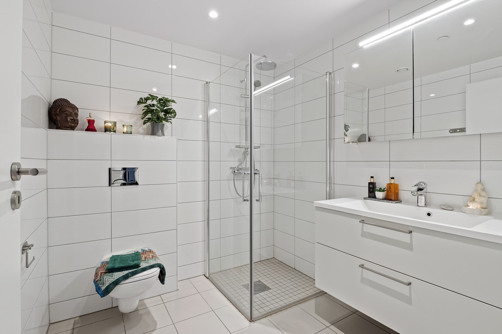 Fra gangen er det videre adkomst til leiligheten sitt andre baderom. Dette badet er i likhet med de øvrige rommene romslig og innbydende, med flislagt gulv og vegger. Galleribilde