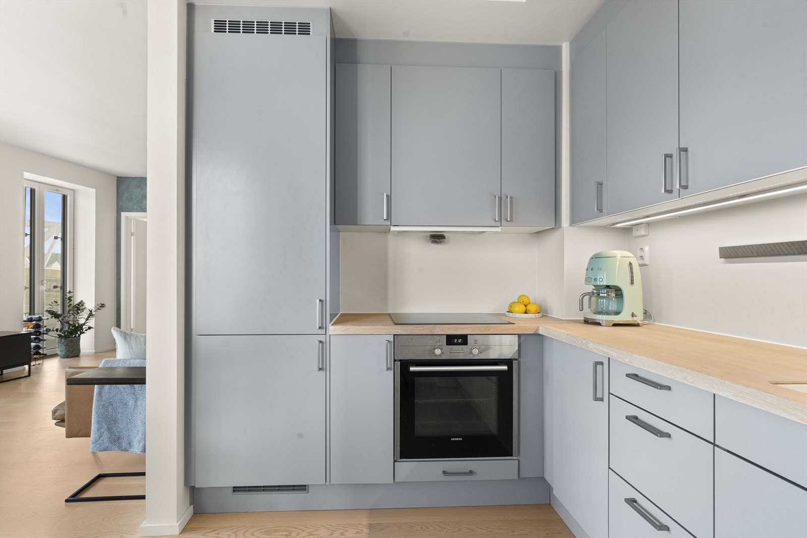 Lekkert Sigdal-kjøkken innredet med slette fronter og benkeplate i heltre Galleribilde