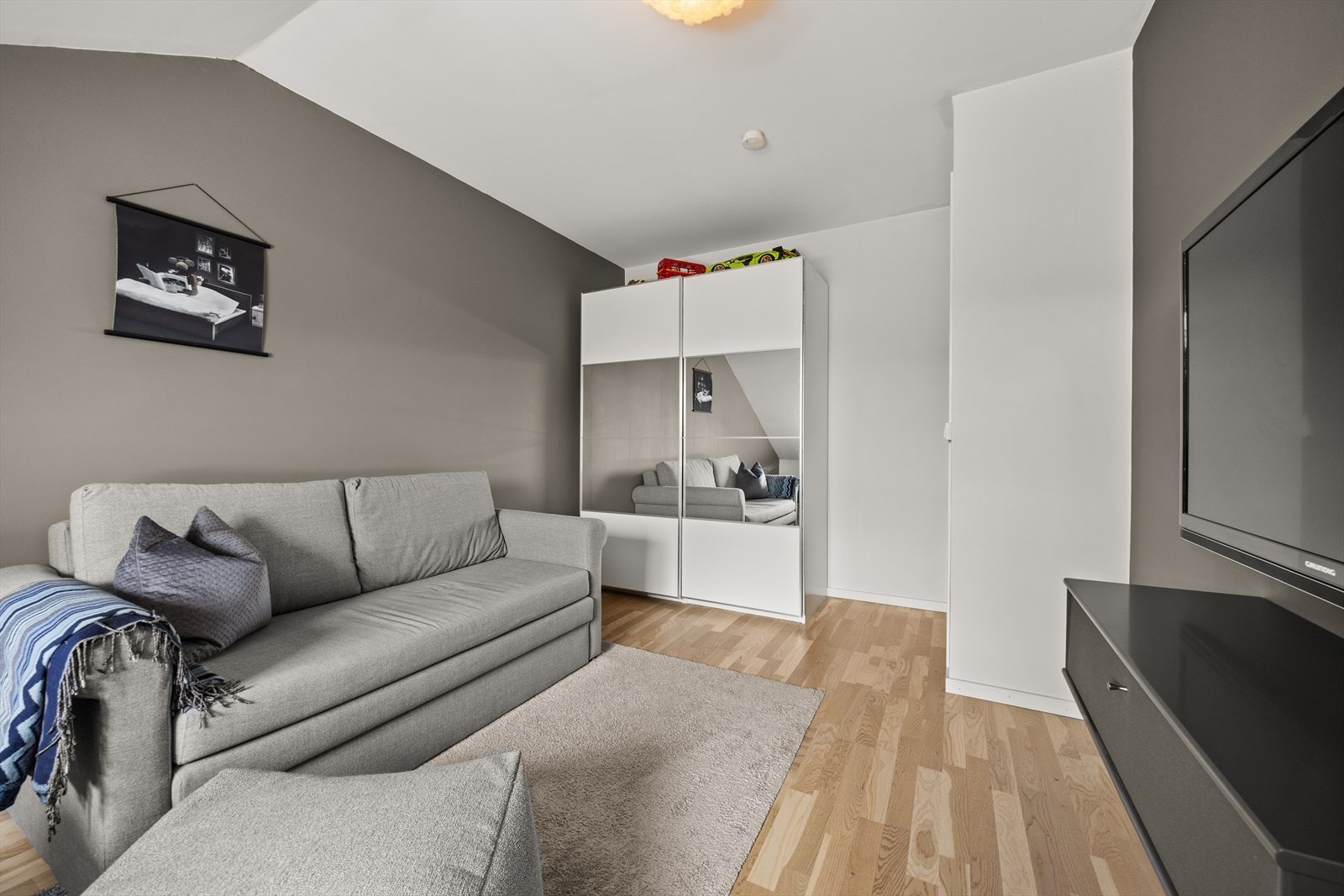 Også romslig med god plass til både seng, sofa, tv-møblement og skap Galleribilde