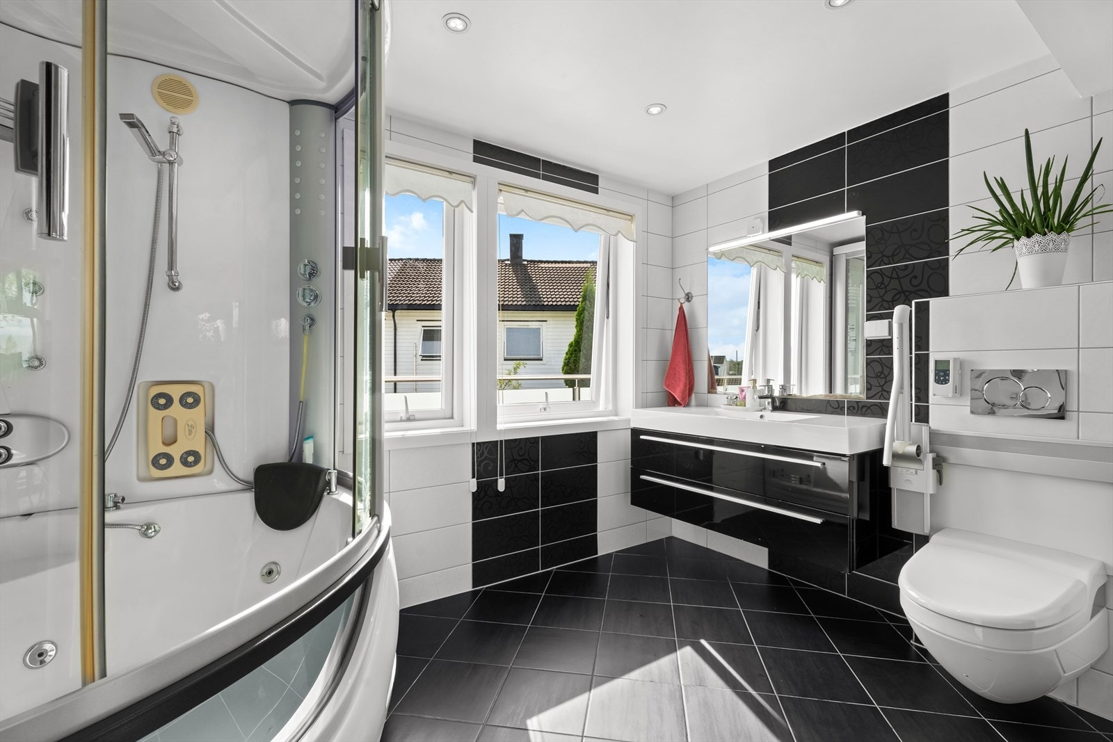 Bad 2 er innredet med dusjkabinett/badekarkabinett, servant, veggfestet klosett med innebygget sisterne og opplegg for vaskemaskin Galleribilde