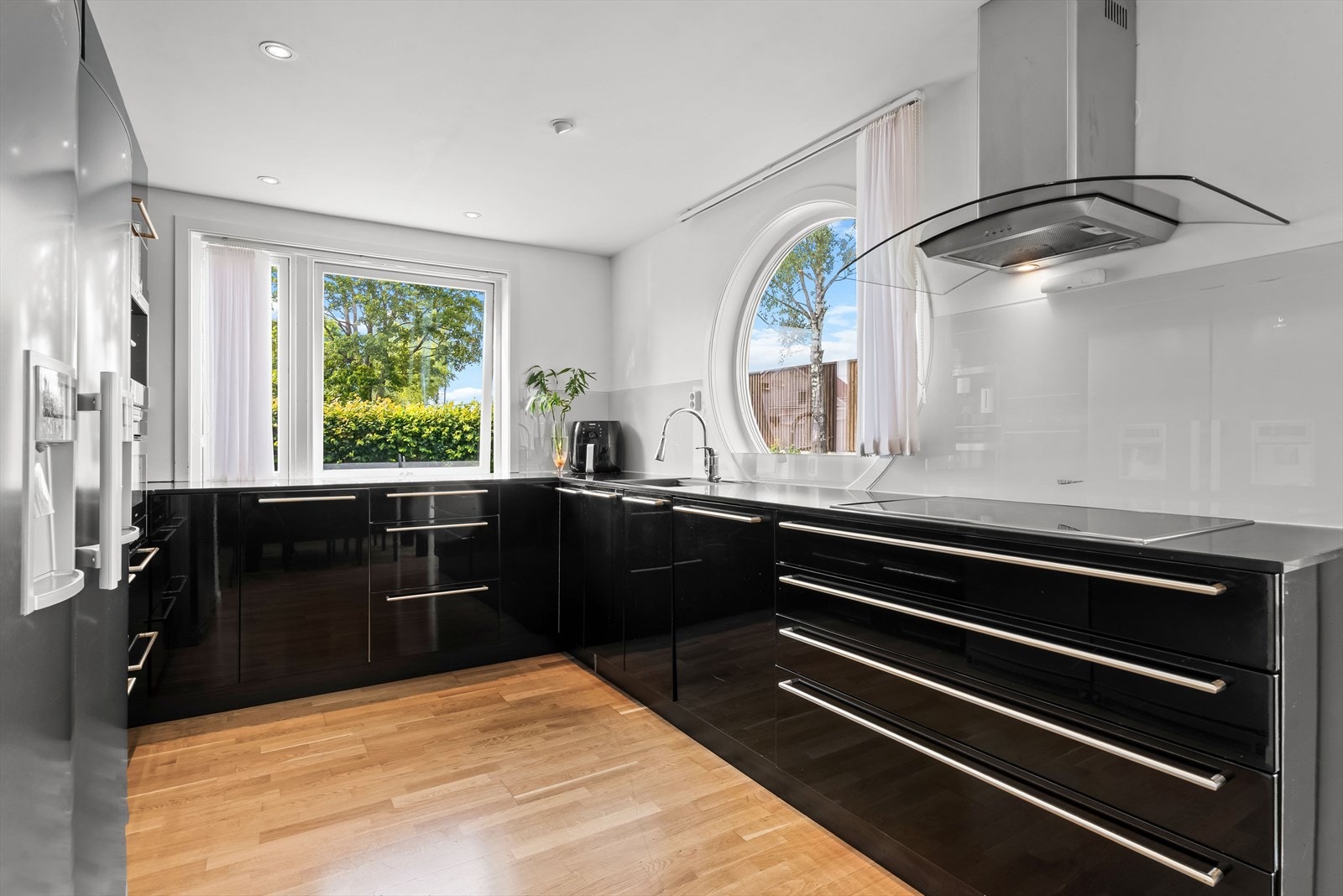 Kjøkkeninnredning med glatte fronter og benkeplate i stein med planlimt kum Galleribilde