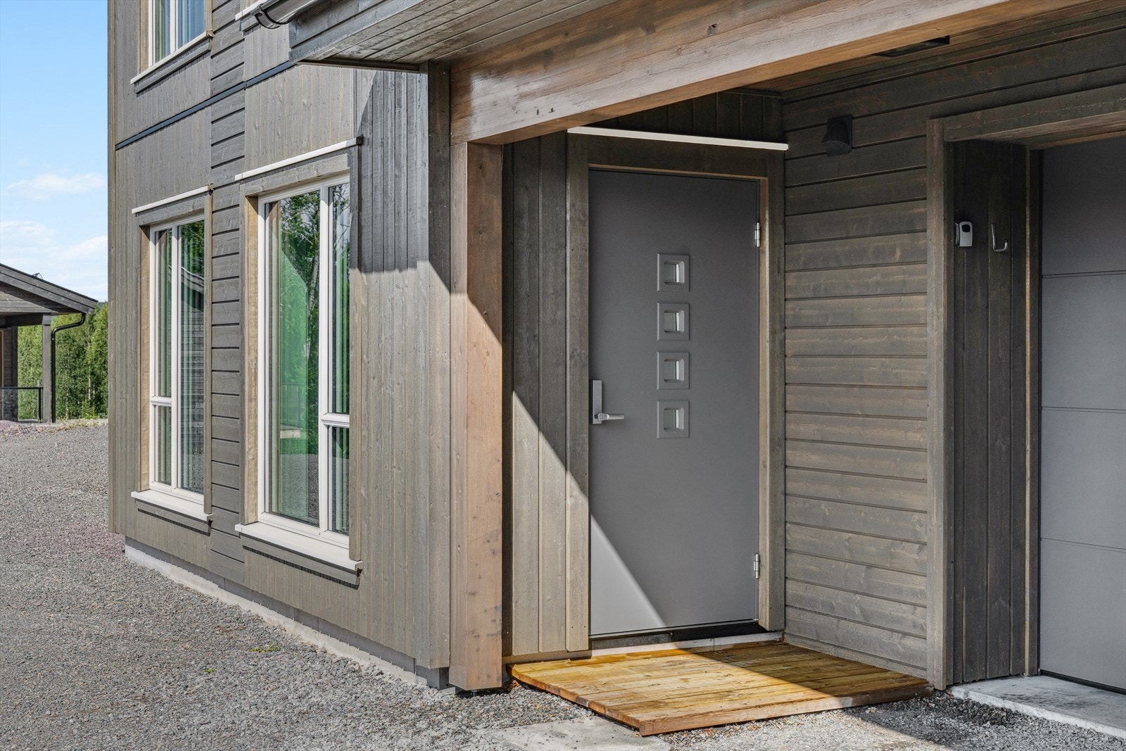 Det er egen inngang til kjellerstuen i underetasjen ved garasjen Galleribilde