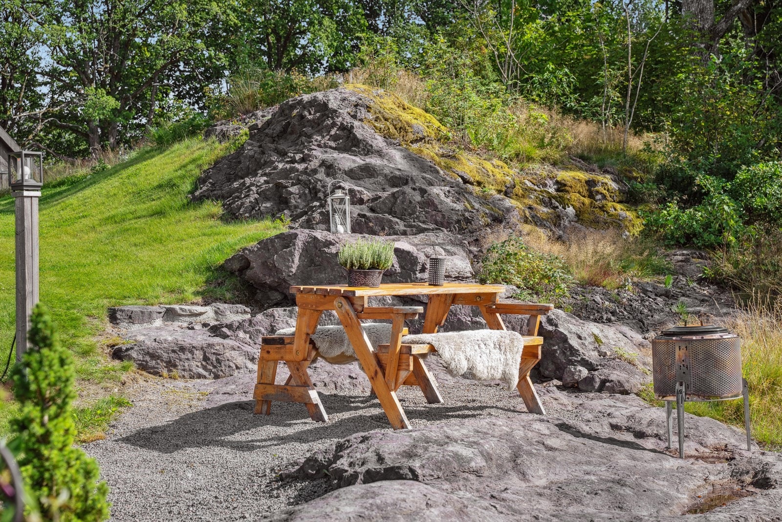 Deler av tomten har flott naturstein og naturlig beplantet med trær Galleribilde