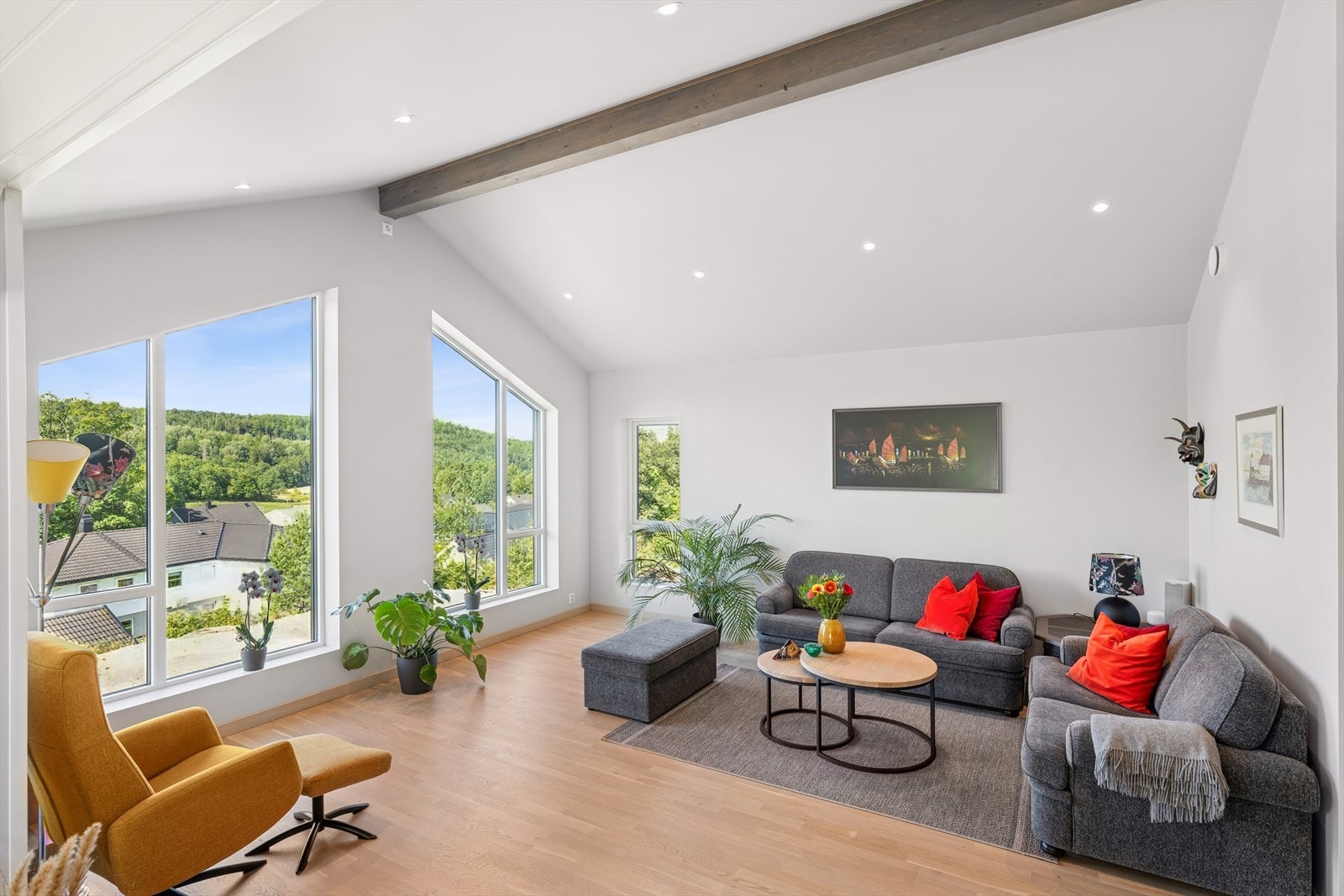 Generøs takhøyde og store vindusflater skaper en god atmosfære i stuen Galleribilde