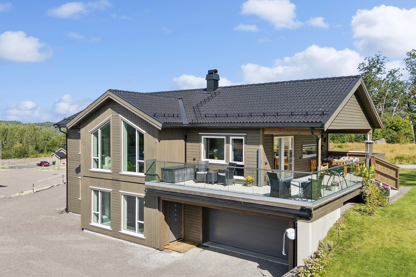 Eiendommens tomt har en stor gruset gårdsplass og en flott opparbeidet plen beplantet med prydbusker. Galleribilde