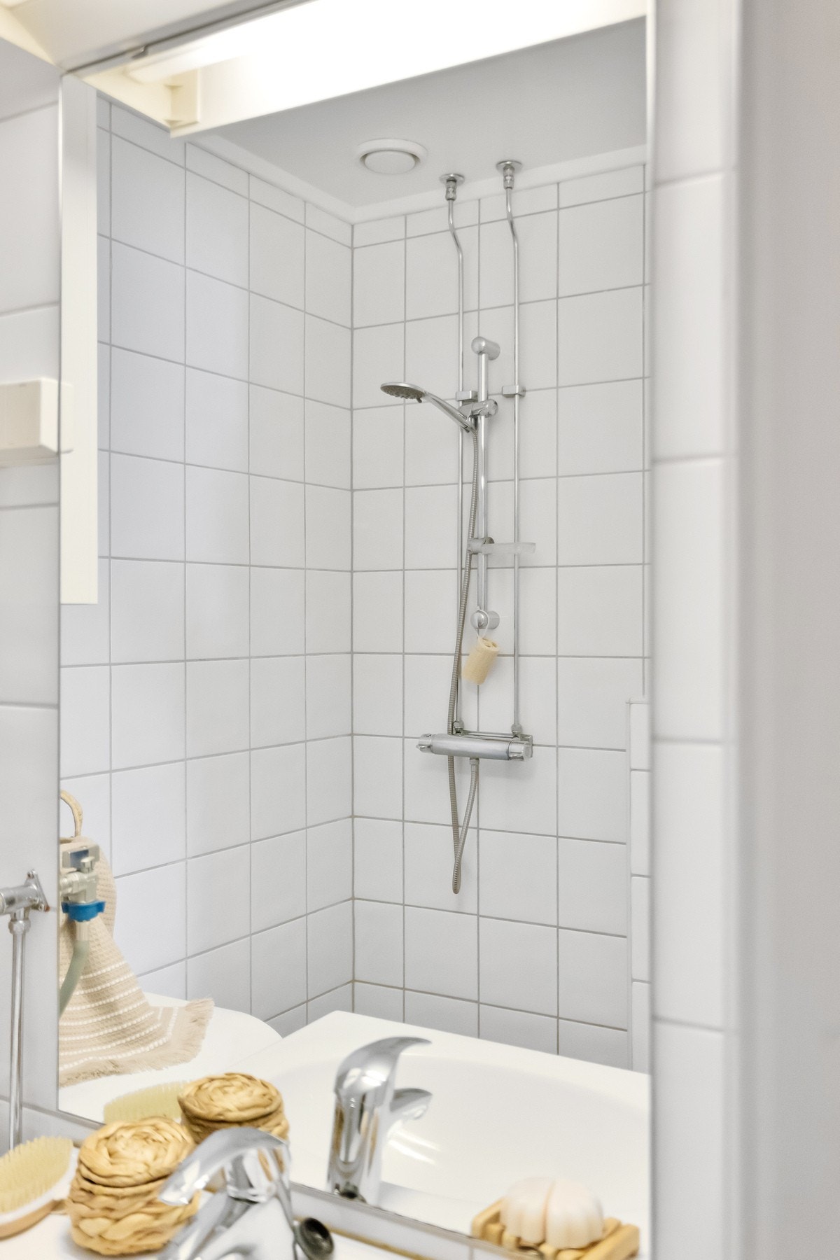 Badet er innredet med vegghengt toalett, dusjhjørne, servantseksjon med skap og speil. Galleribilde