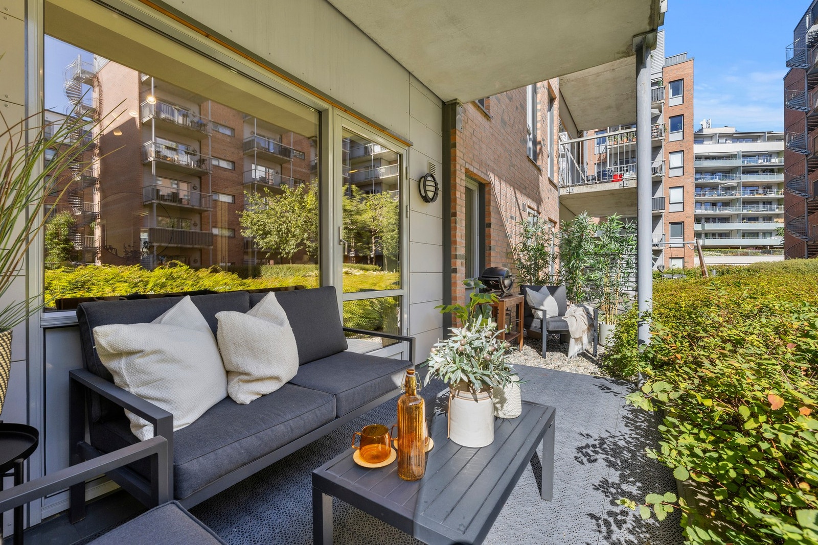 Leiligheten har en romslig markterrasse som er skjermet for innsyn. Terrassen vender mot en lukket, opphøyd bakgård, som består av både sittegrupper og en lekeplass. Galleribilde