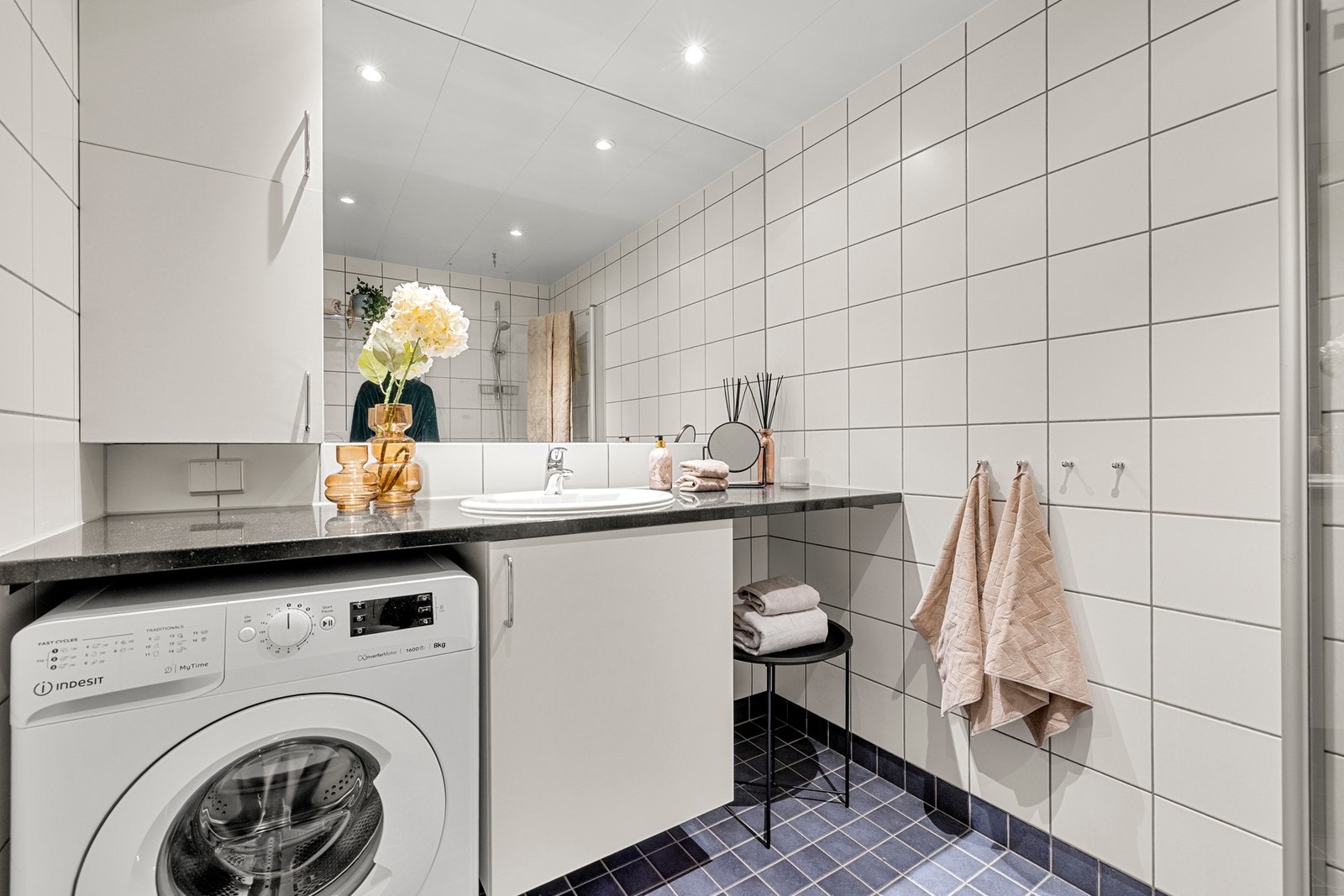 Det er opplegg for både vaskemaskin og tørketrommel på badet, diskret plassert inn under benkeplaten i stein. Galleribilde