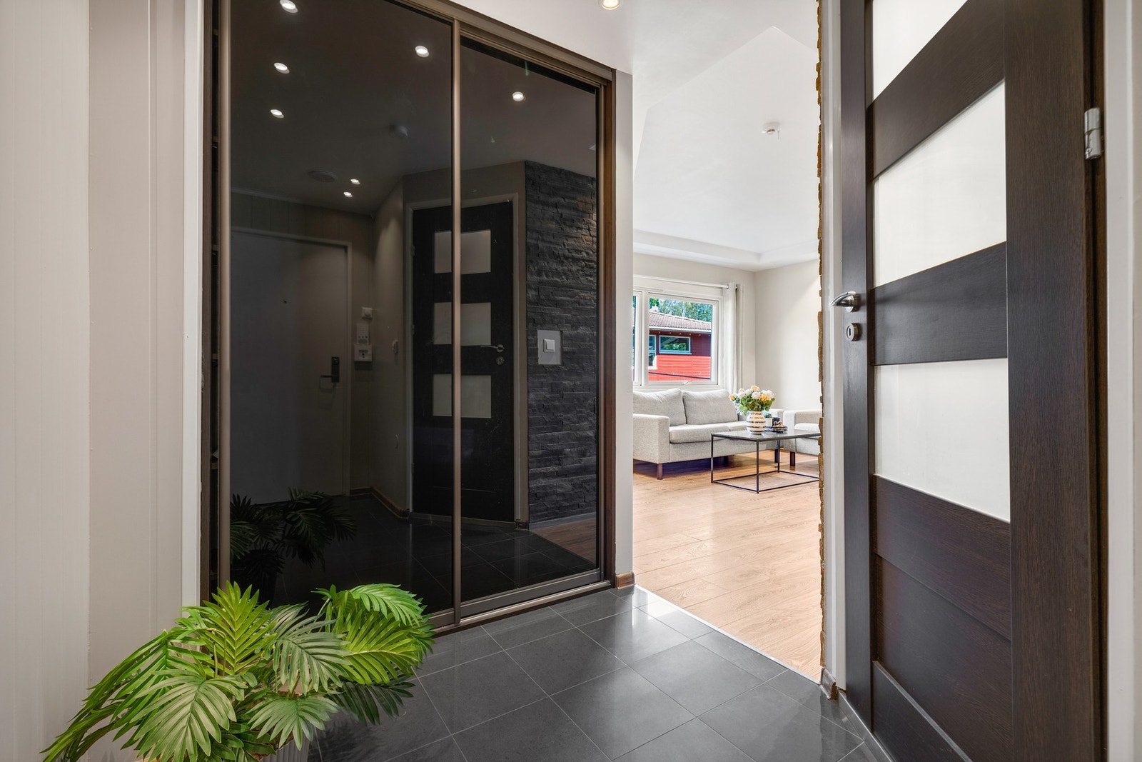 Entréen er også flislagt med lune varmekabler i gulvet. God oppbevaringsplass i en stor skyvedørsgarderobe. Galleribilde