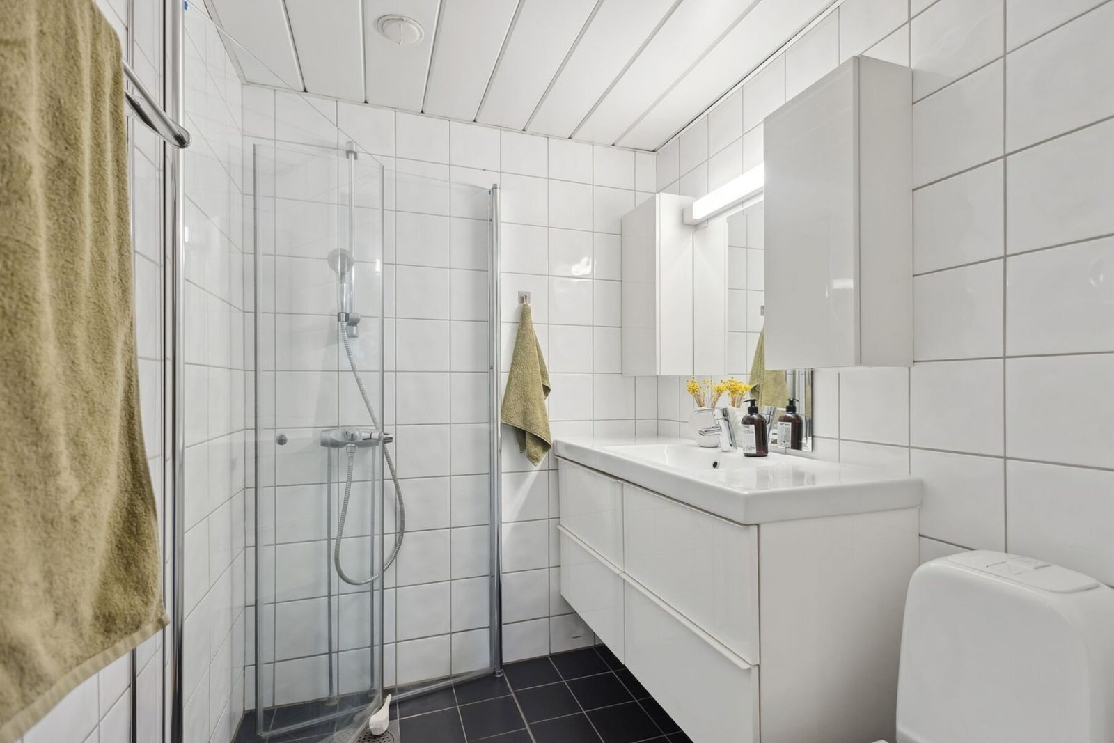 Leilighetens rolige og helhetlige preg fortsetter inn på badet, som er pent flislagt og utstyrt med det du trenger i hverdagen. Galleribilde