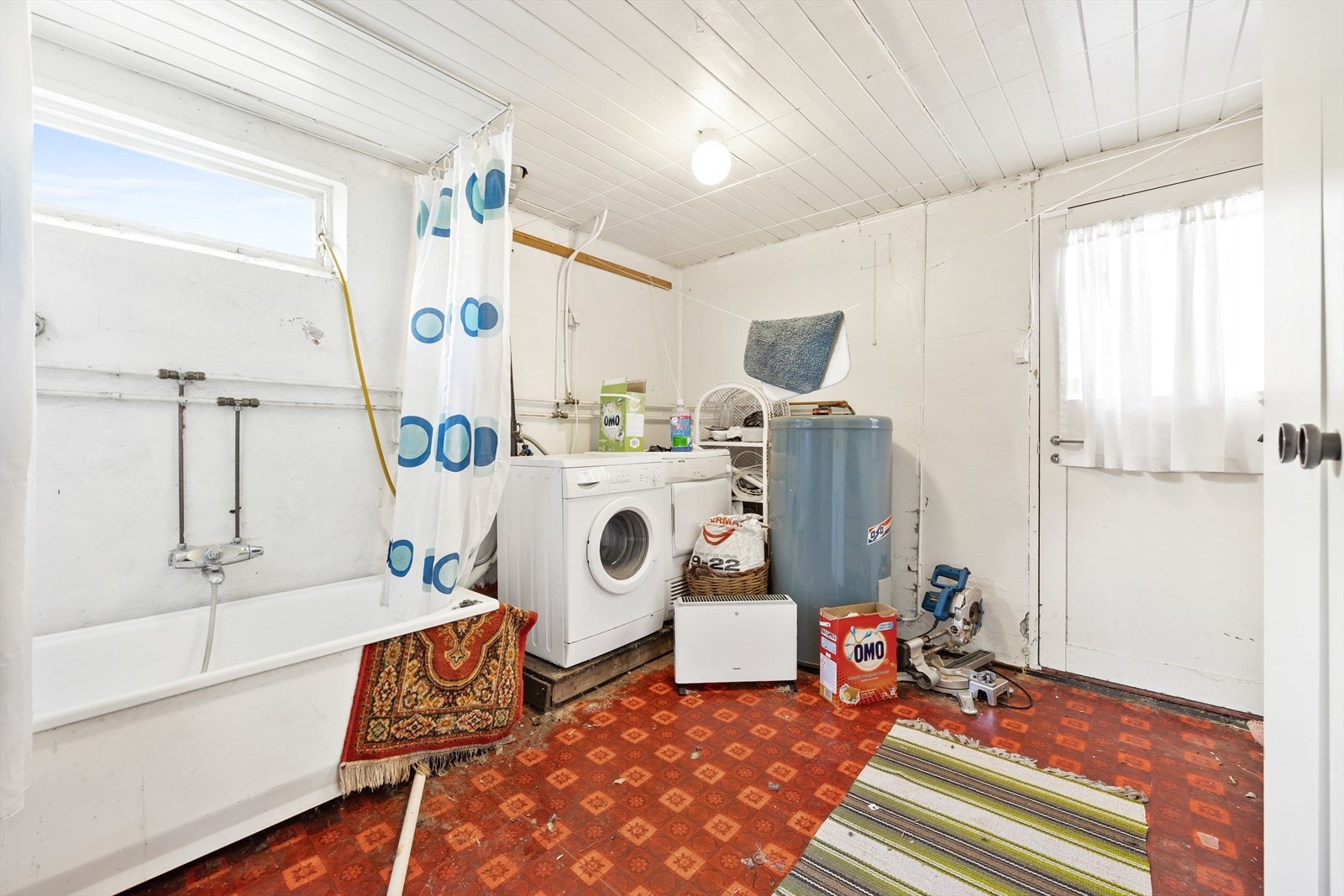 Praktisk vaskerom med badekar, opplegg for vaskemaskin/tørketrommel og plassering av varmtvannsbereder. Galleribilde