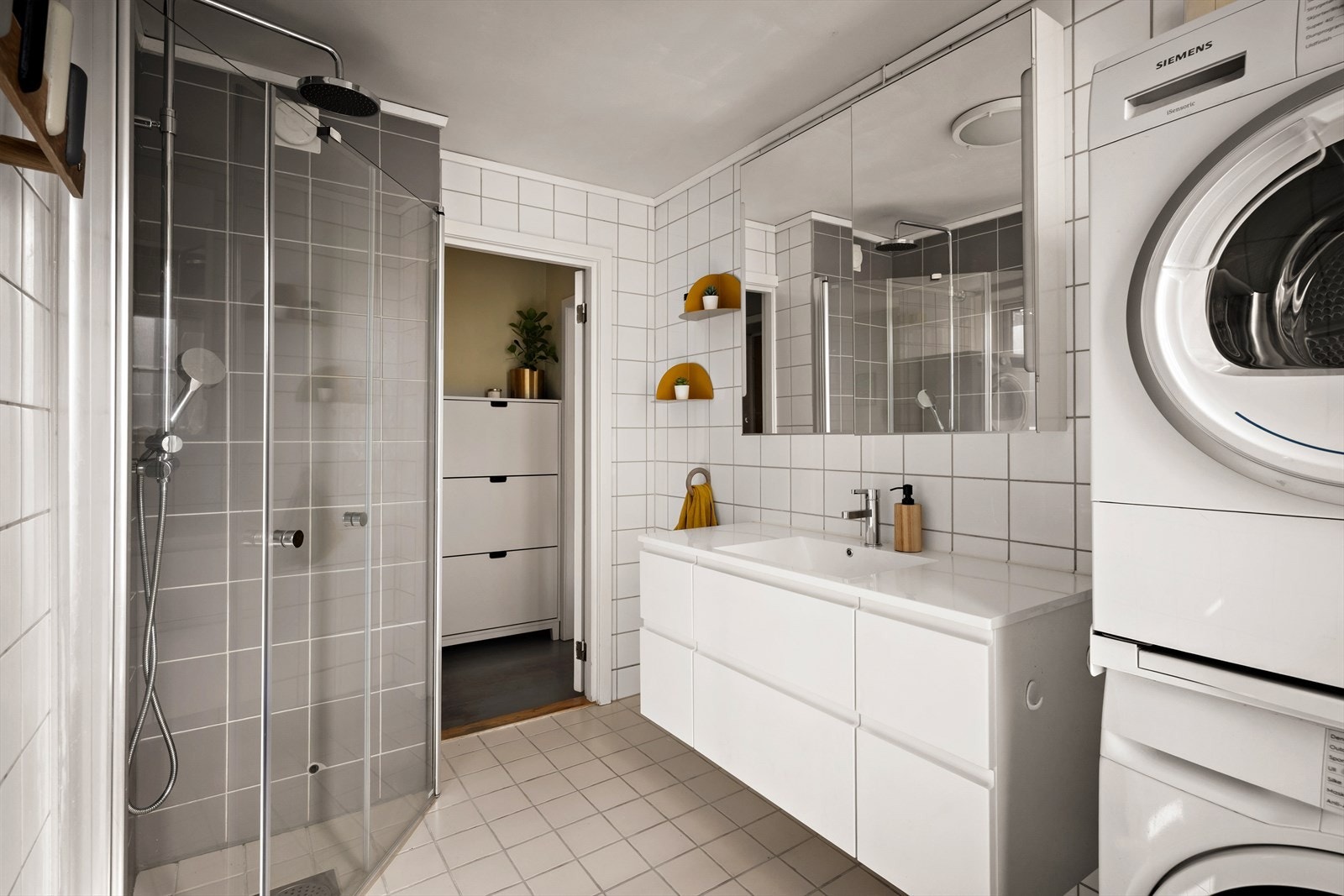 Badet er fliselagt med dusj, servantinnredning, toalett og plass til vaskemaskin/tørketrommel. Galleribilde