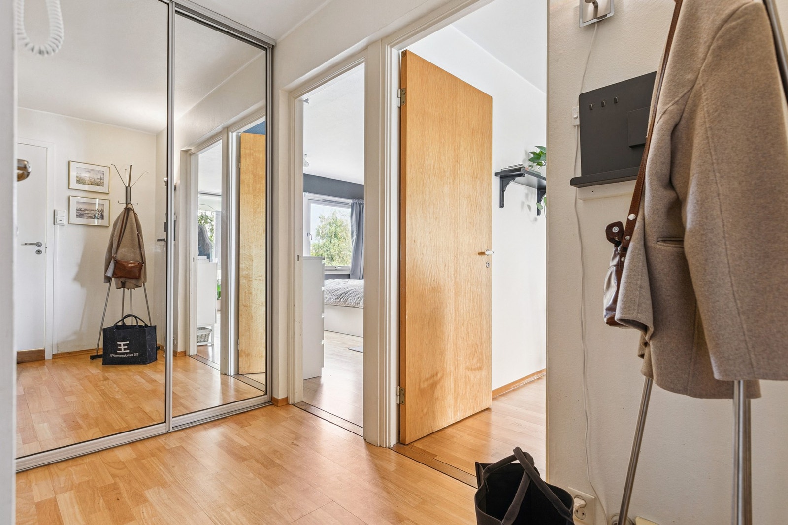 Velkommen inn i en romslig entre med skyvedørsgarderobe. Galleribilde