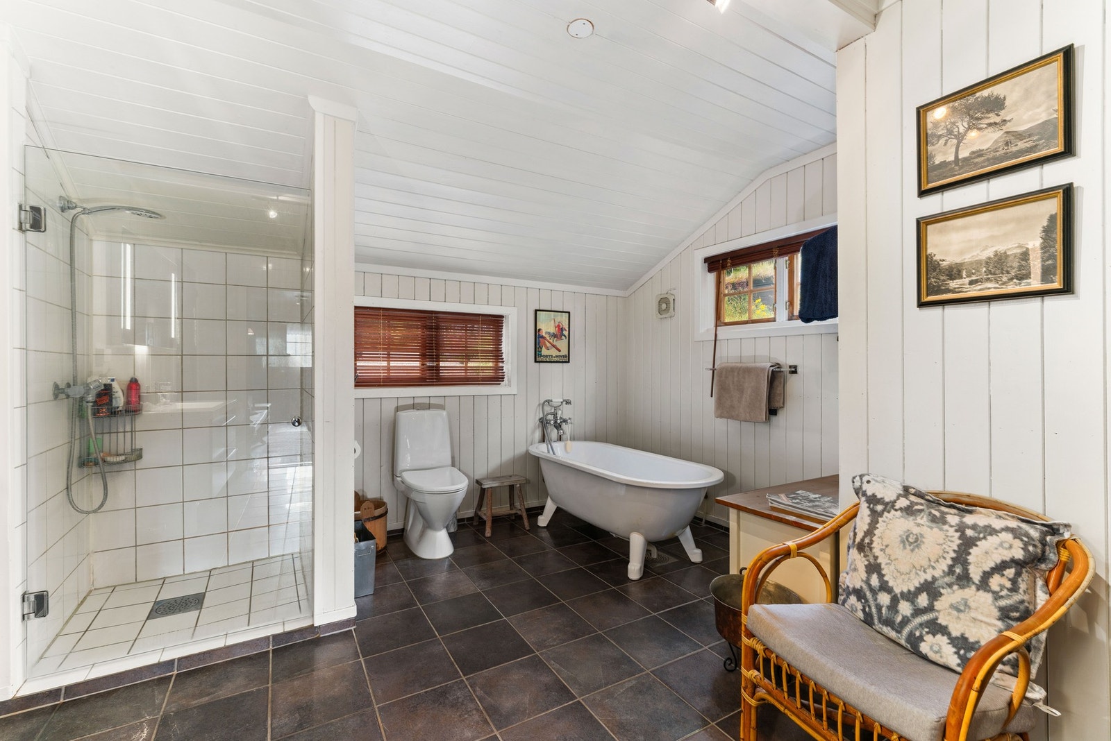 I første etasje finner du også et stort bad, der fliser og panel skaper en balansert kombinasjon av tradisjon og funksjonalitet. Her er det både badekar og dusjhjørne, toalett og servantinnredning fra 2018. Galleribilde