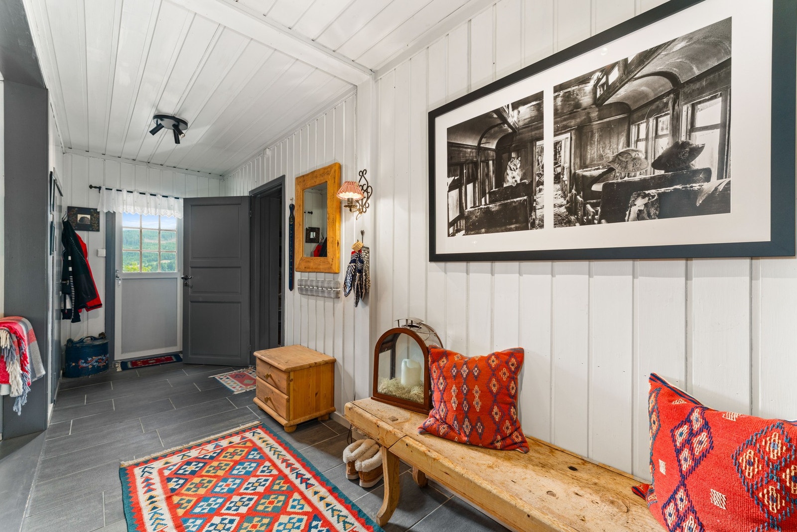 Her er det flislagt gulv med varmekabler som gir en behagelig velkomst, og rikelig med plass til oppbevaring. En tilhørende bod gir deg ekstra lagringsmuligheter rett ved inngangen. Galleribilde