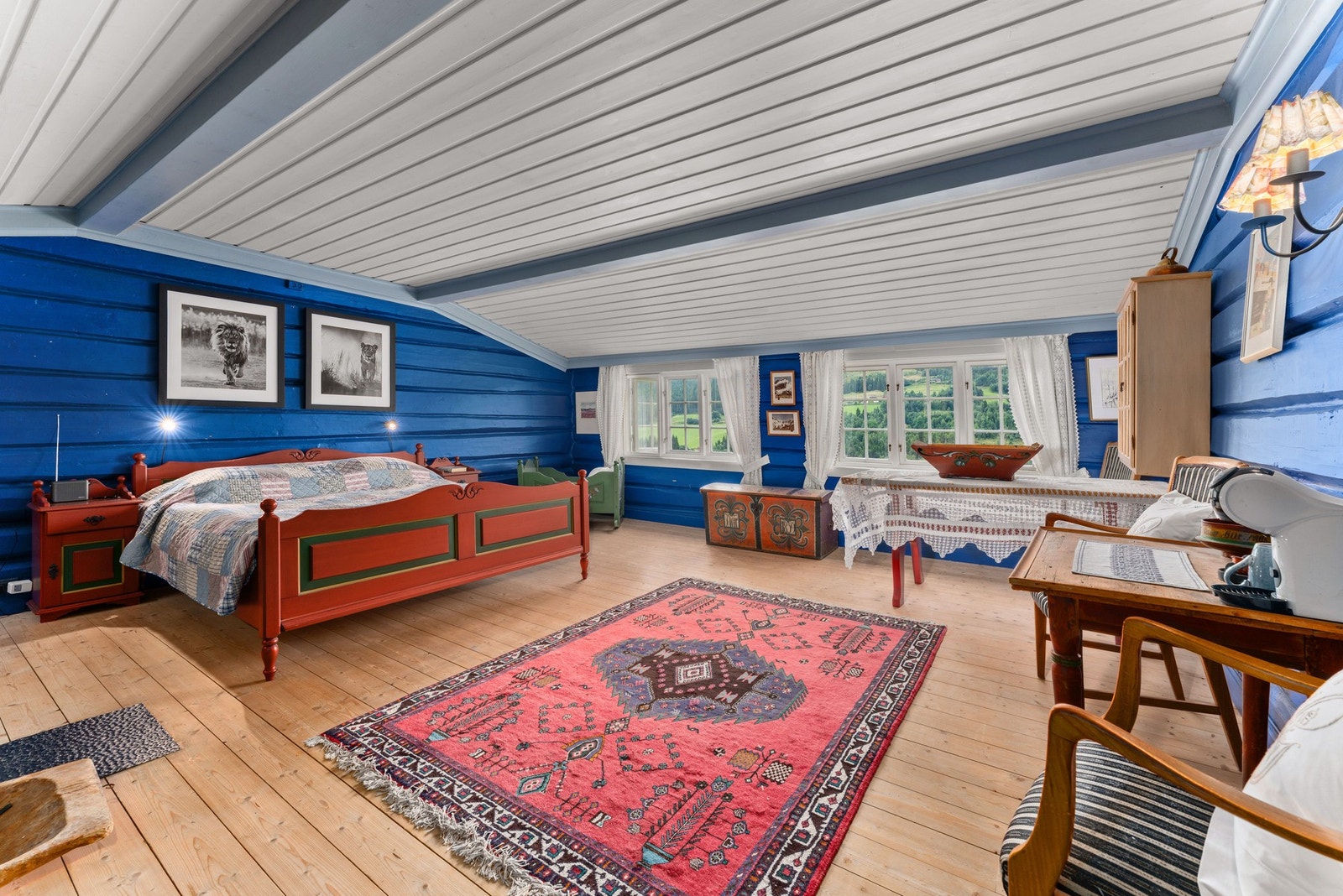 Hovedsoverommet er malt i en flott, blå tømmervegg, dekorert med tradisjonelle detaljer. Galleribilde