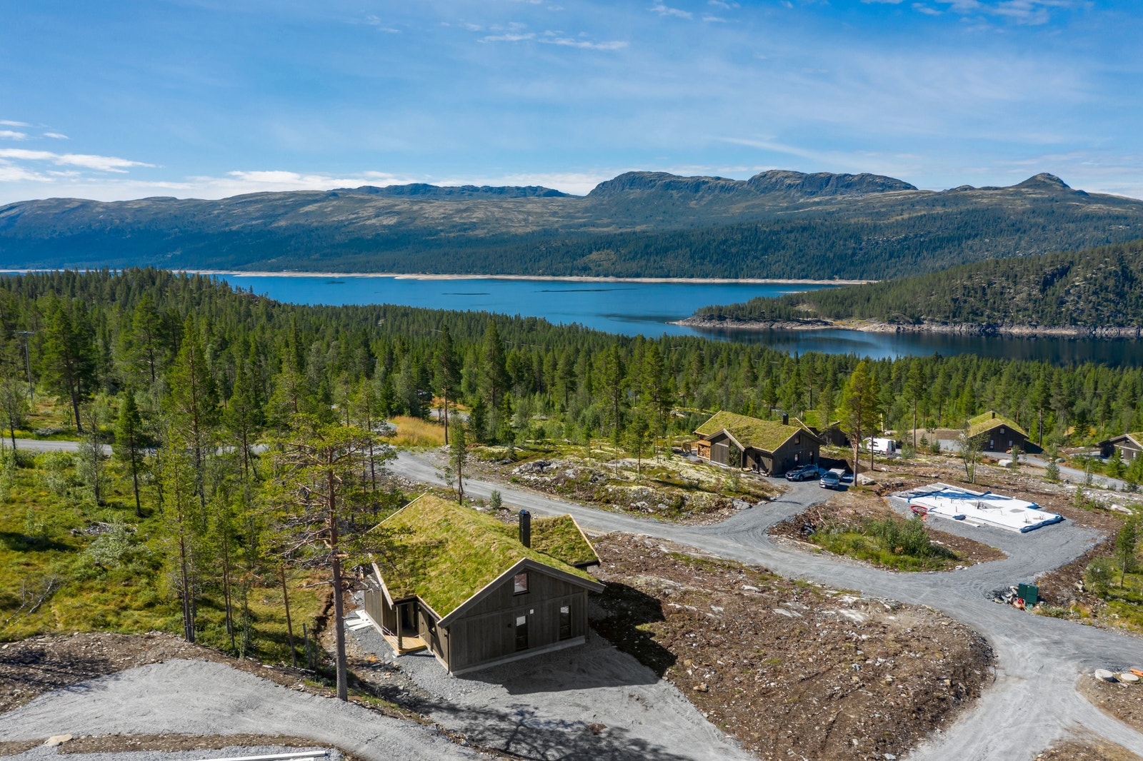 Hytten ligger øverst i feltet, høyt og fritt over nærliggende hytter Galleribilde