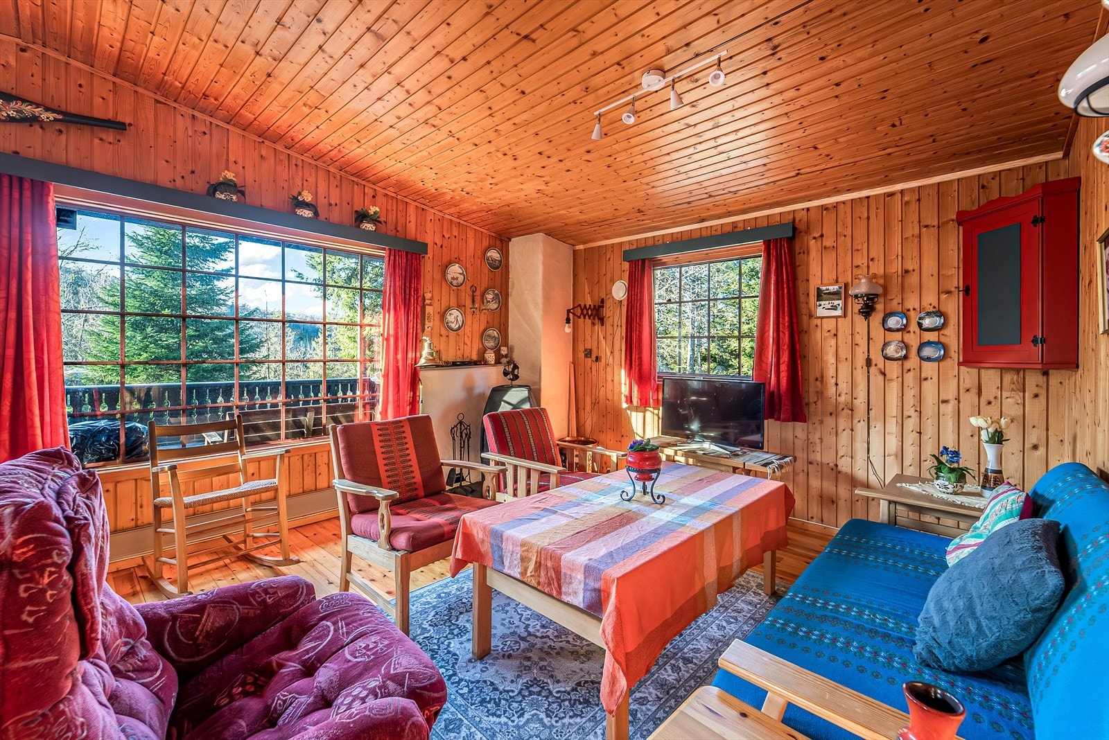 Koselig stue med store vinduer som gir mye naturlig lys. Sjarmerende detaljer og fin utsikt mot naturen utenfor. Galleribilde