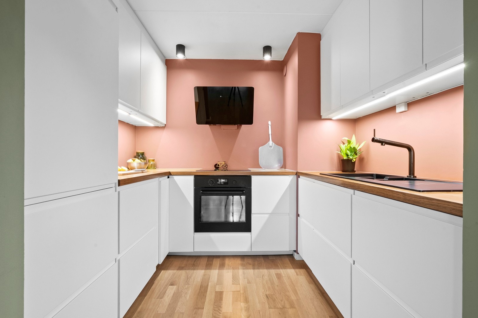 Det er benkeplate av tre, nedfelt oppvaskkum med ett-greps kjøkkenarmatur, i tillegg til benekeskapsbelysning og stikkontakter over kjøkkenbenk. Galleribilde