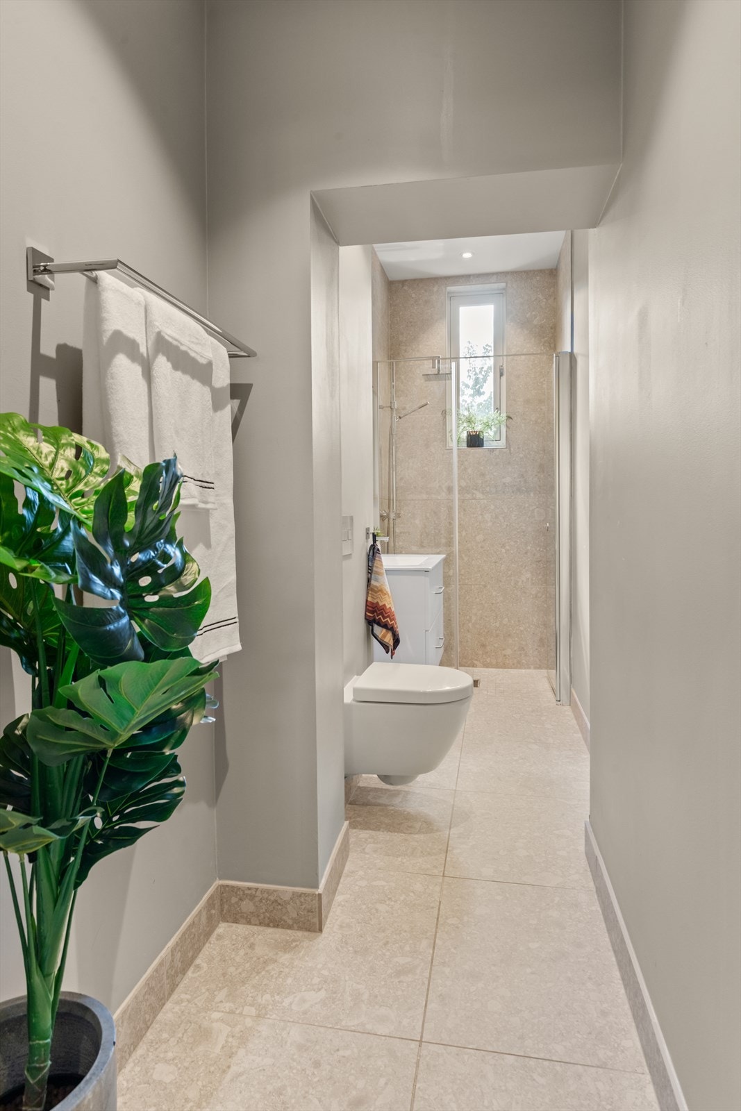 Badet er innredet med servant med speil, dusj med dusjarmatur og vegghengt toalett. Galleribilde