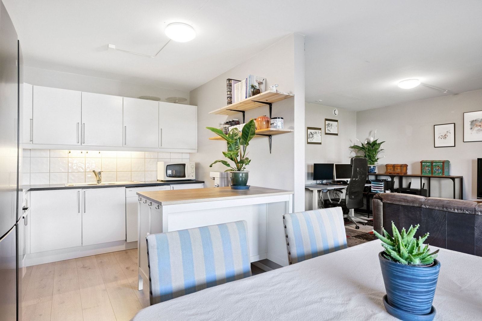 Åpen kjøkkenløsning og kjøkkenøy med stor benkplass Galleribilde