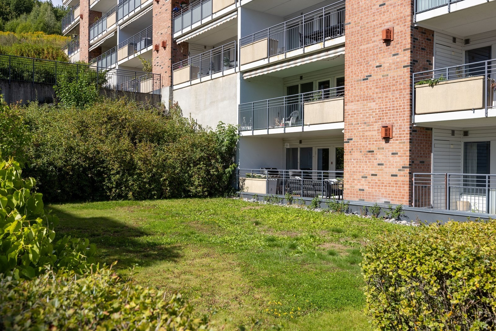 Grøntarealet foran balkongen skaper en trivelig ramme rundt boligen og gir en fin utsikt fra terrassen. Galleribilde
