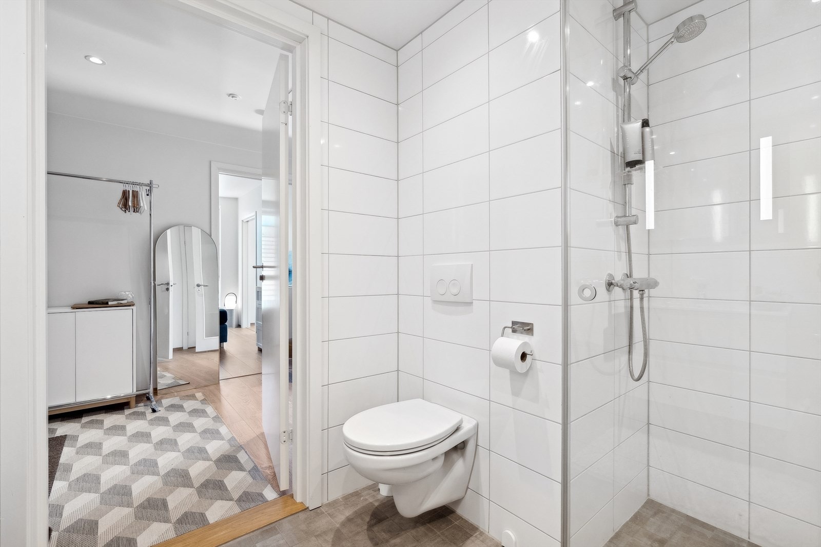 Badet er meget tiltalende med moderne fliser på vegg og innfelte LED-spotter. Gulvet er flislagt og med varme. Galleribilde