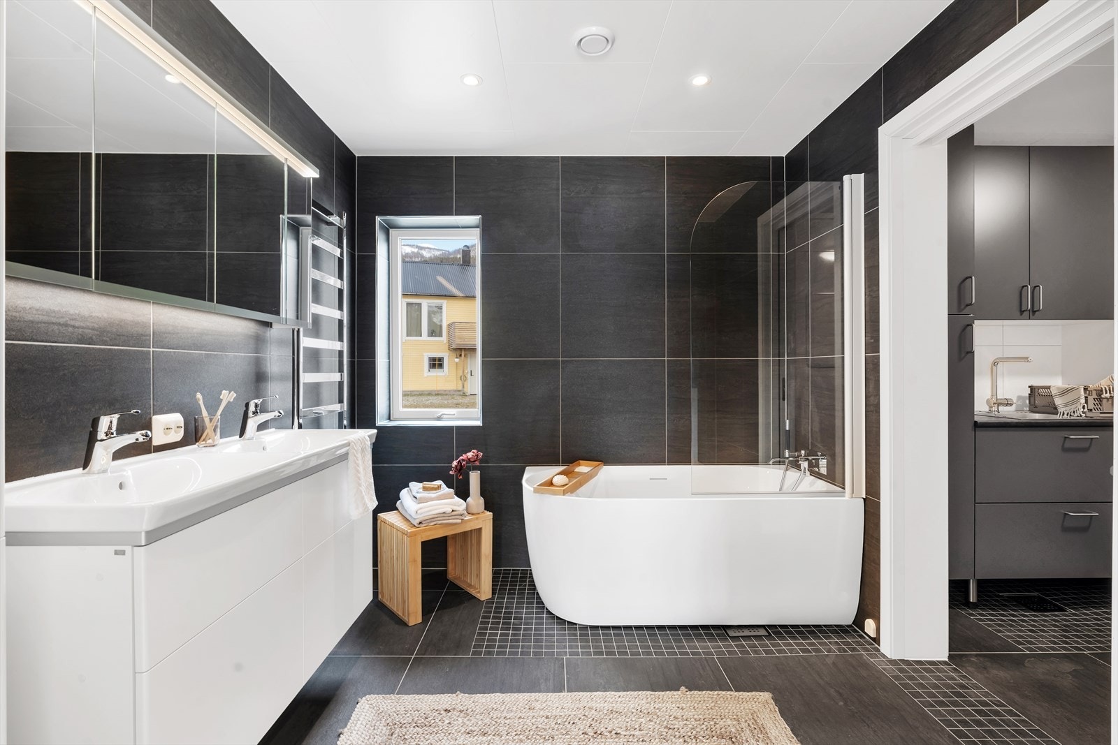 Nydelig, komplett flislagt bad med mørke storformatfliser og lekre baderomsinnredninger. Galleribilde