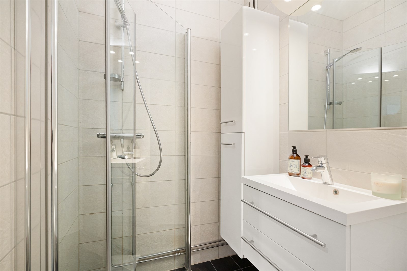 Baderomsinnredning bestående av høyskap, speilskap, underskap og servant med 1-greps blandebatteri i rustfritt stål fra Hans Grohe. Galleribilde