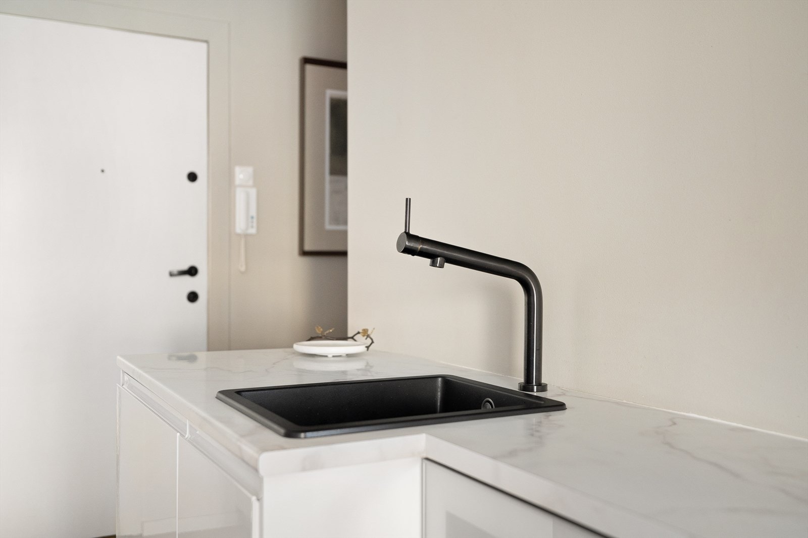 Laminatbenkeplate i delikat marmormønster med nedfelt sort vaskekum og 1-greps blandebatteri. Galleribilde