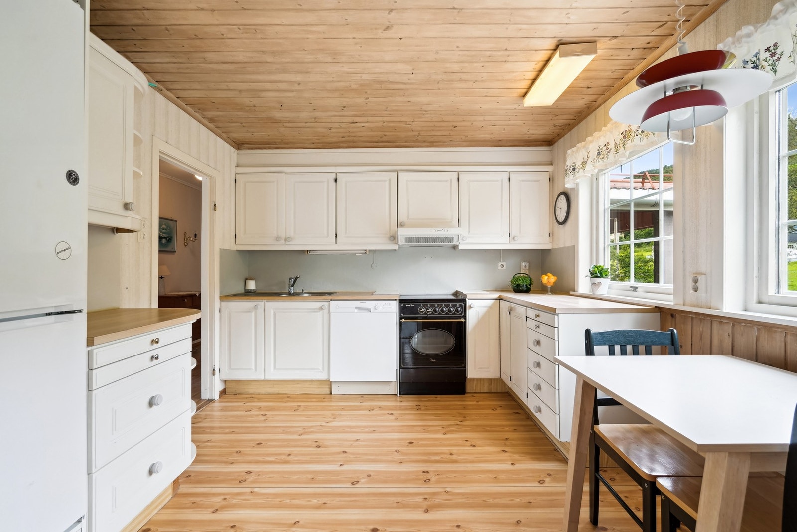 Lyst kjøkken med plass til kjøkkenbord og stoler. Galleribilde