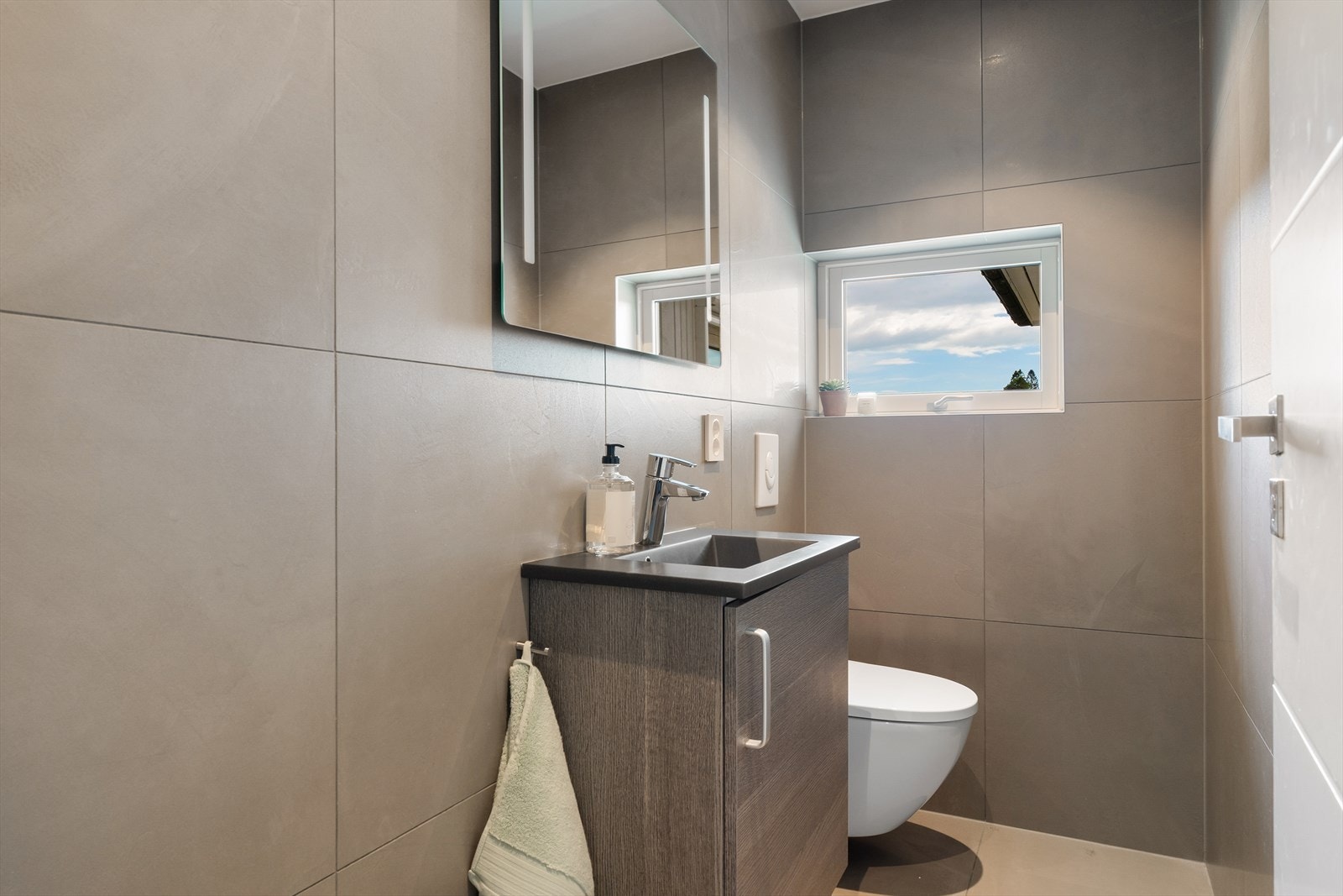 Gjestetoalett innredet med baderomsinnredning med servant og toalett. Galleribilde