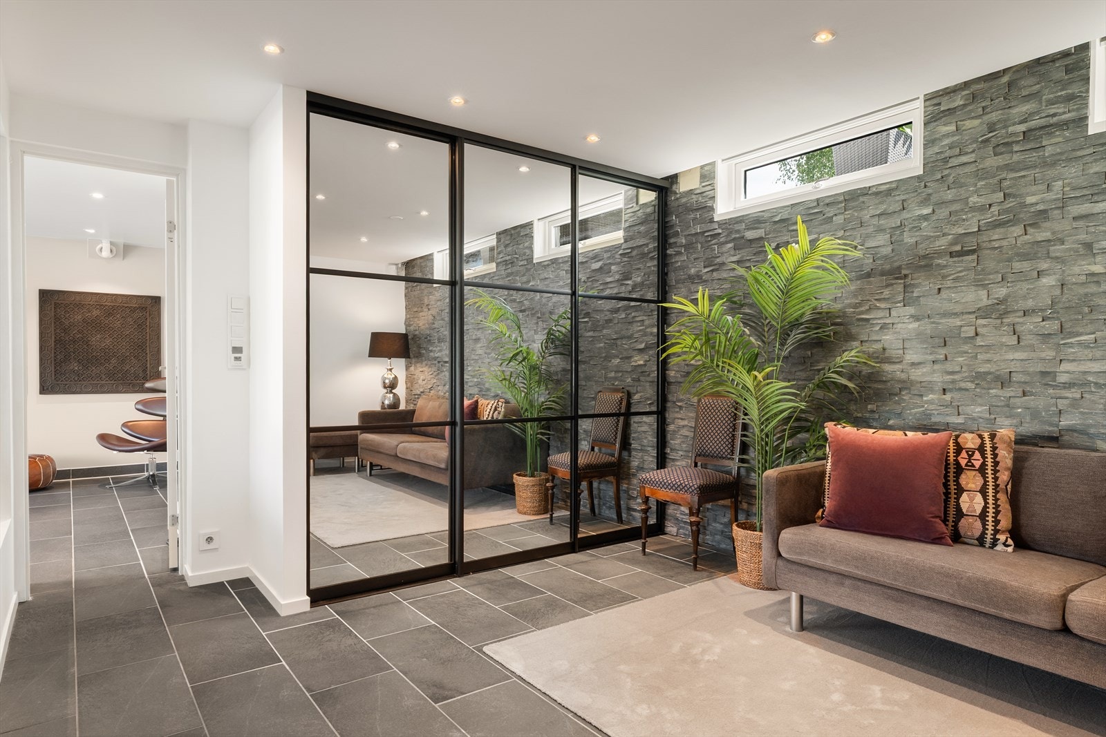 Romslighet og luksus, skyvedørsgarderober i speil og sofagruppe skaper en eksklusiv atmosfære av ryddige, klassiske linjer Galleribilde