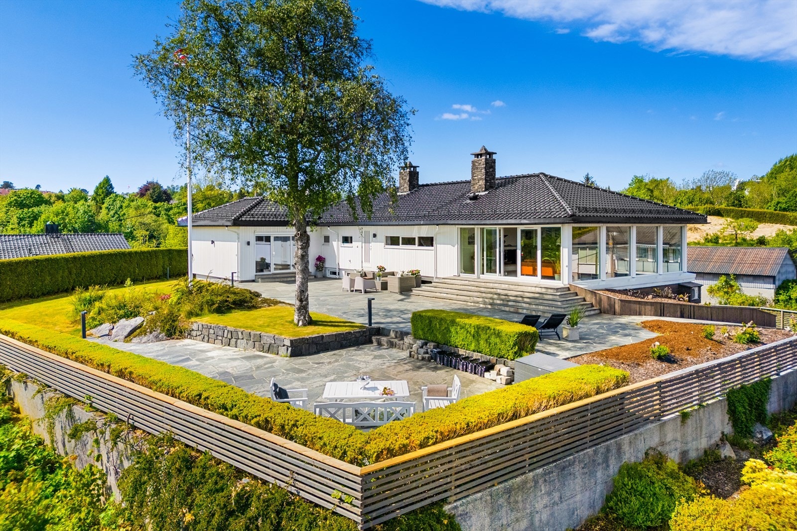 Meget pent opparbeidet tomt med terrasser, store plenareal og variert beplantning. Galleribilde