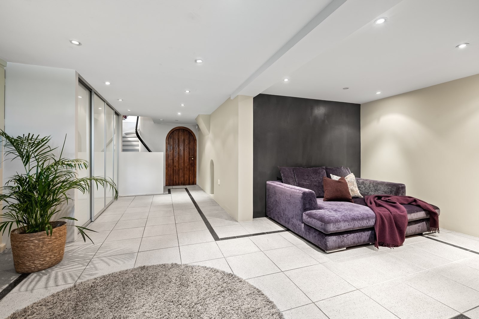 Stor hall med fliser på gulv og bred skyvedørsgarderobe. Galleribilde