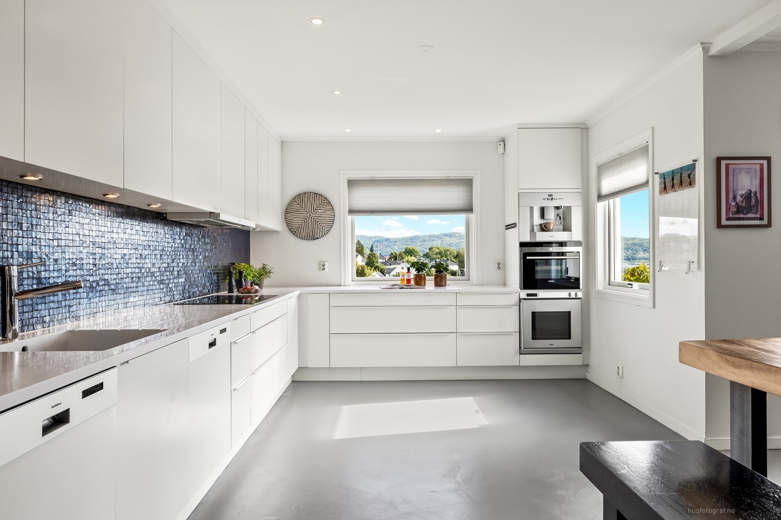 Benkeplate og vask er av Corian, med mosaikkfliser over benk og spotter under overskap. Galleribilde