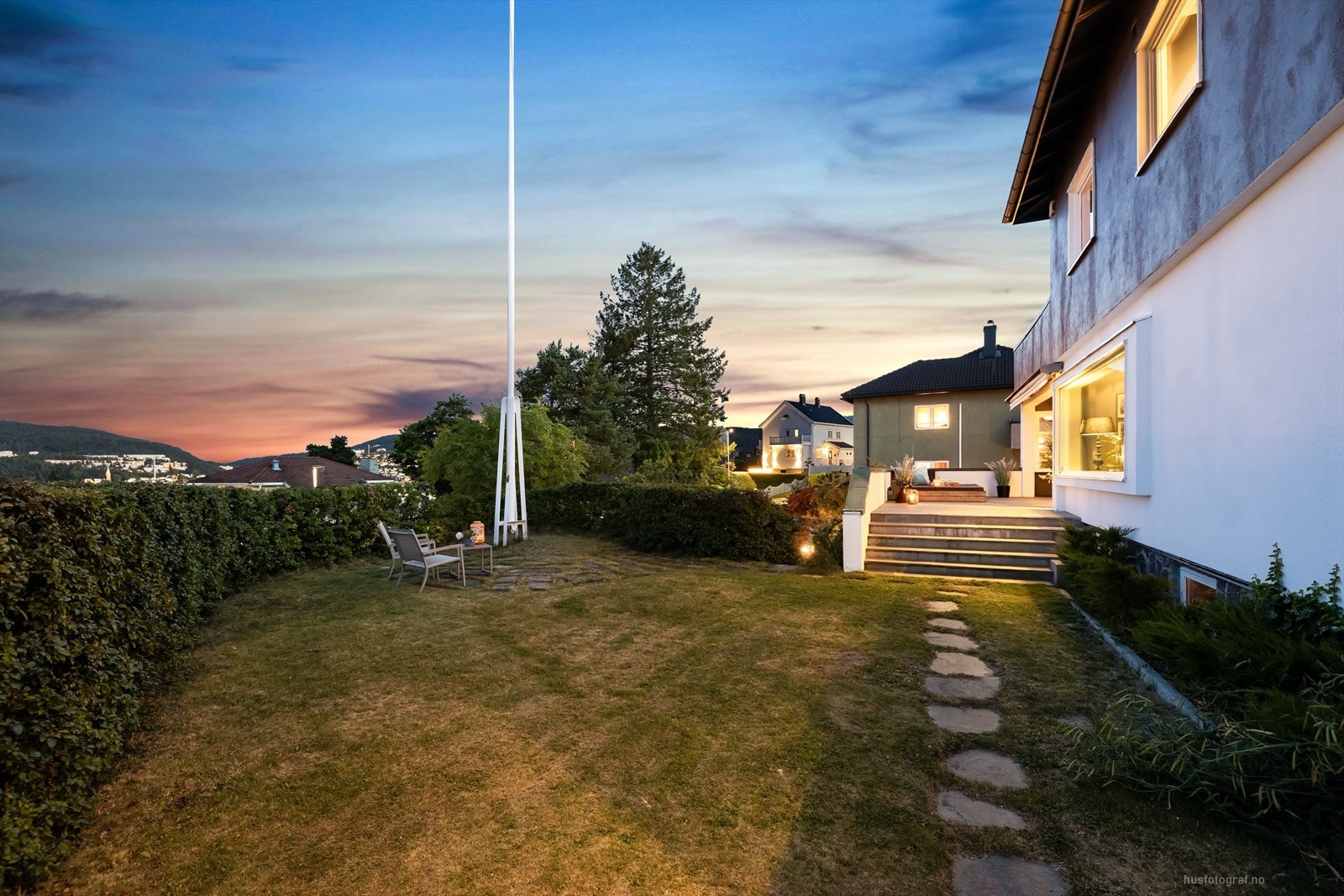 Privat hage av fin størrelse og med skifer i stier og uteplass ved flaggstangen pryder eiendommen. Galleribilde