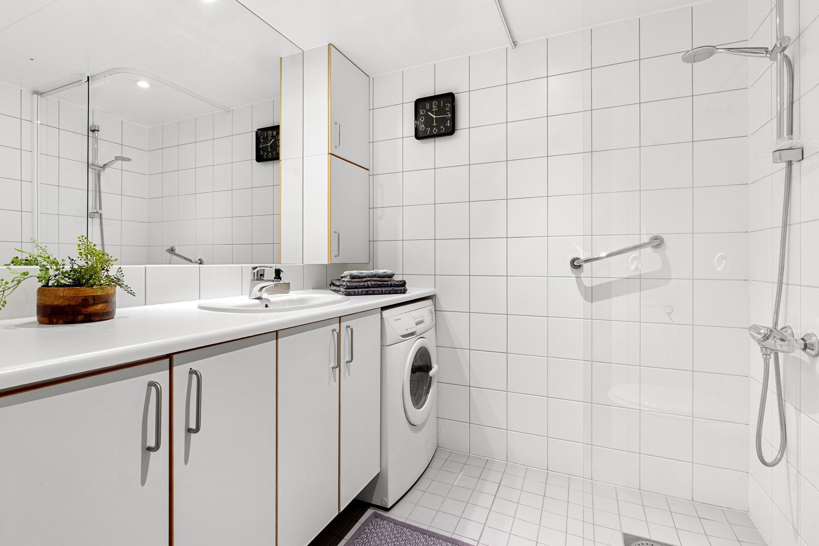 Badet har god skapplass med underskap og overskap i tillegg til et stort vegghengende speil over servant Galleribilde