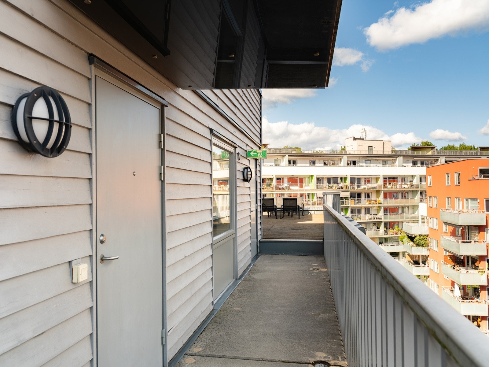 En svalgang leder videre til leiligheten, og det er enkel tilgang til felles takterrasse som ligger bare noen få skritt fra inngangsdøren. Galleribilde