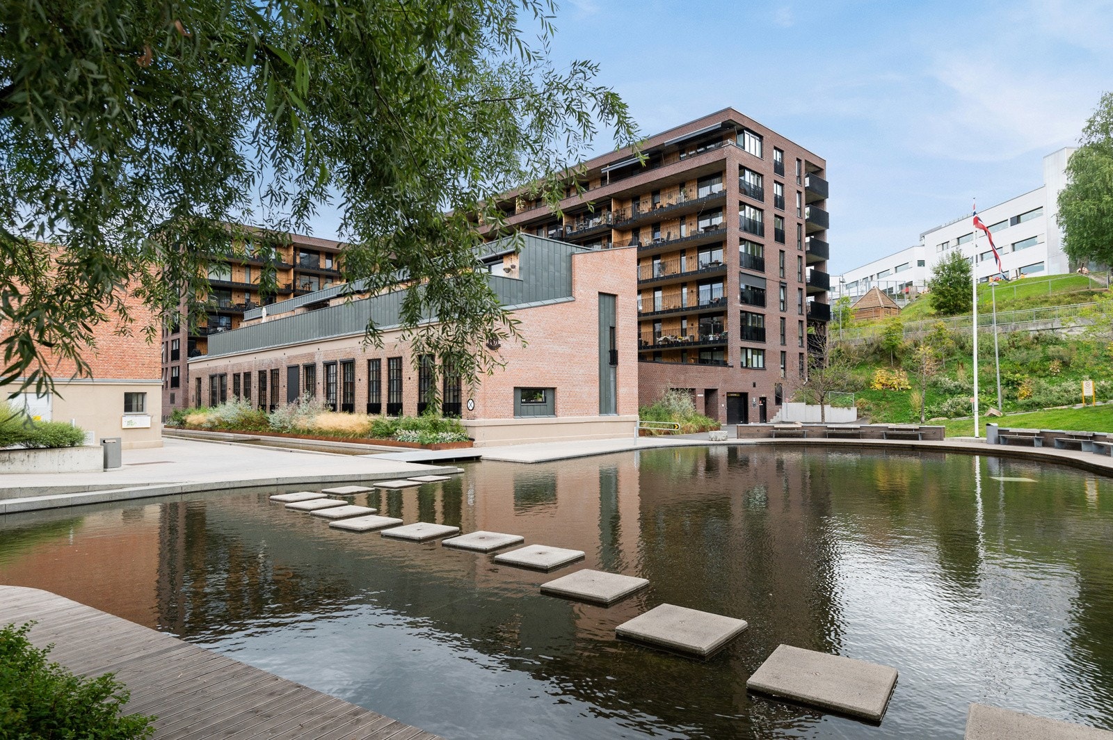 Området har parkmessig preg med Alnaelva som vannspeil, samt ulike butikker, kaféer og god bussforbindelse. Galleribilde