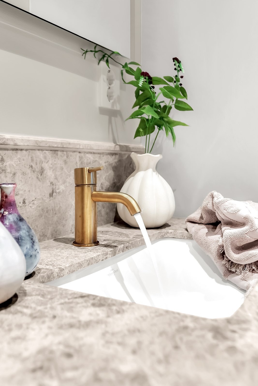 Badet er utstyrt med veggmontert toalett, servant med skap, speil og belysning, samt opplegg for vaskemaskin. Galleribilde