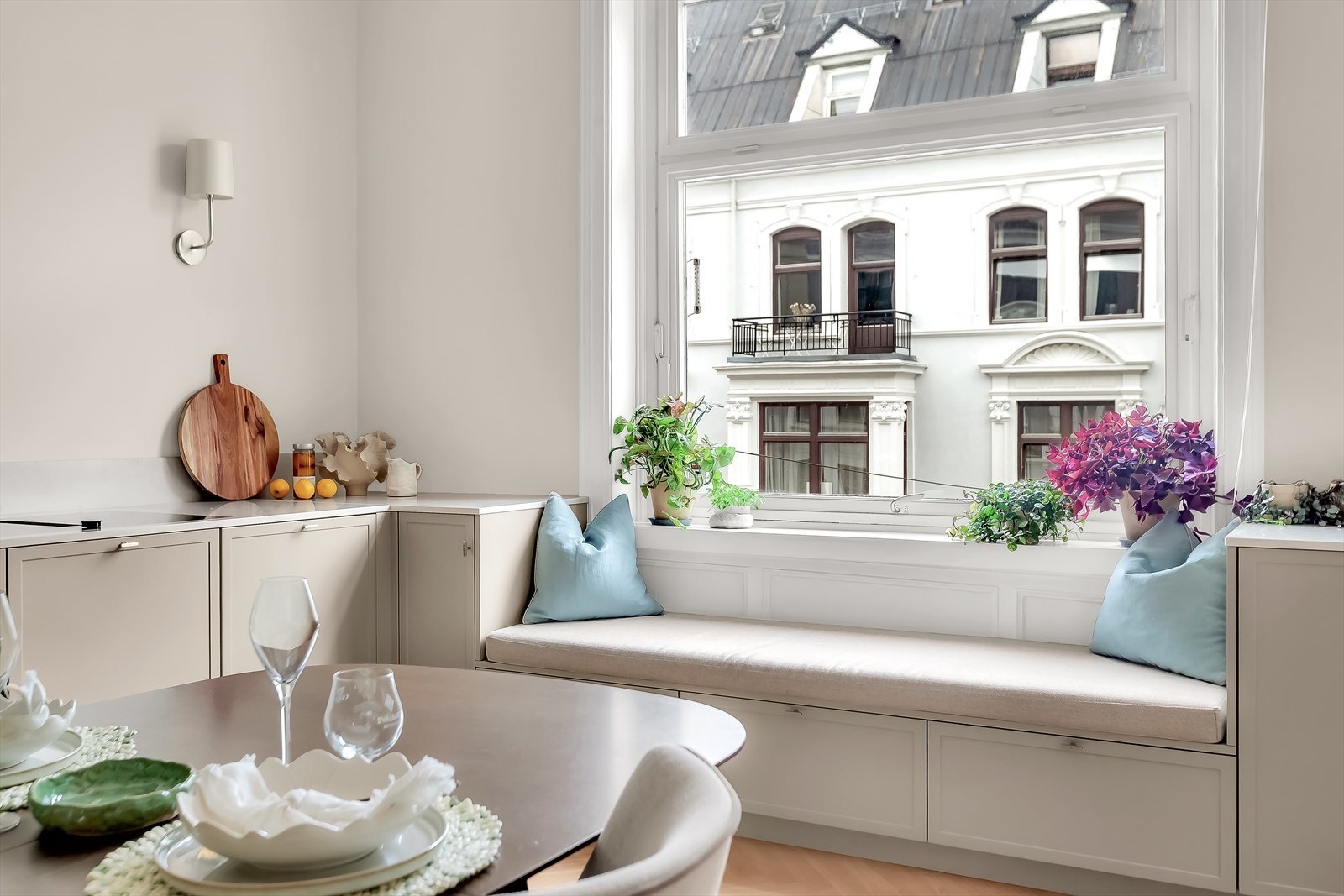 En benk er sømløst integrert i kjøkkeninnredningen ved vinduet, og gir en lun og praktisk sitteplass. Galleribilde